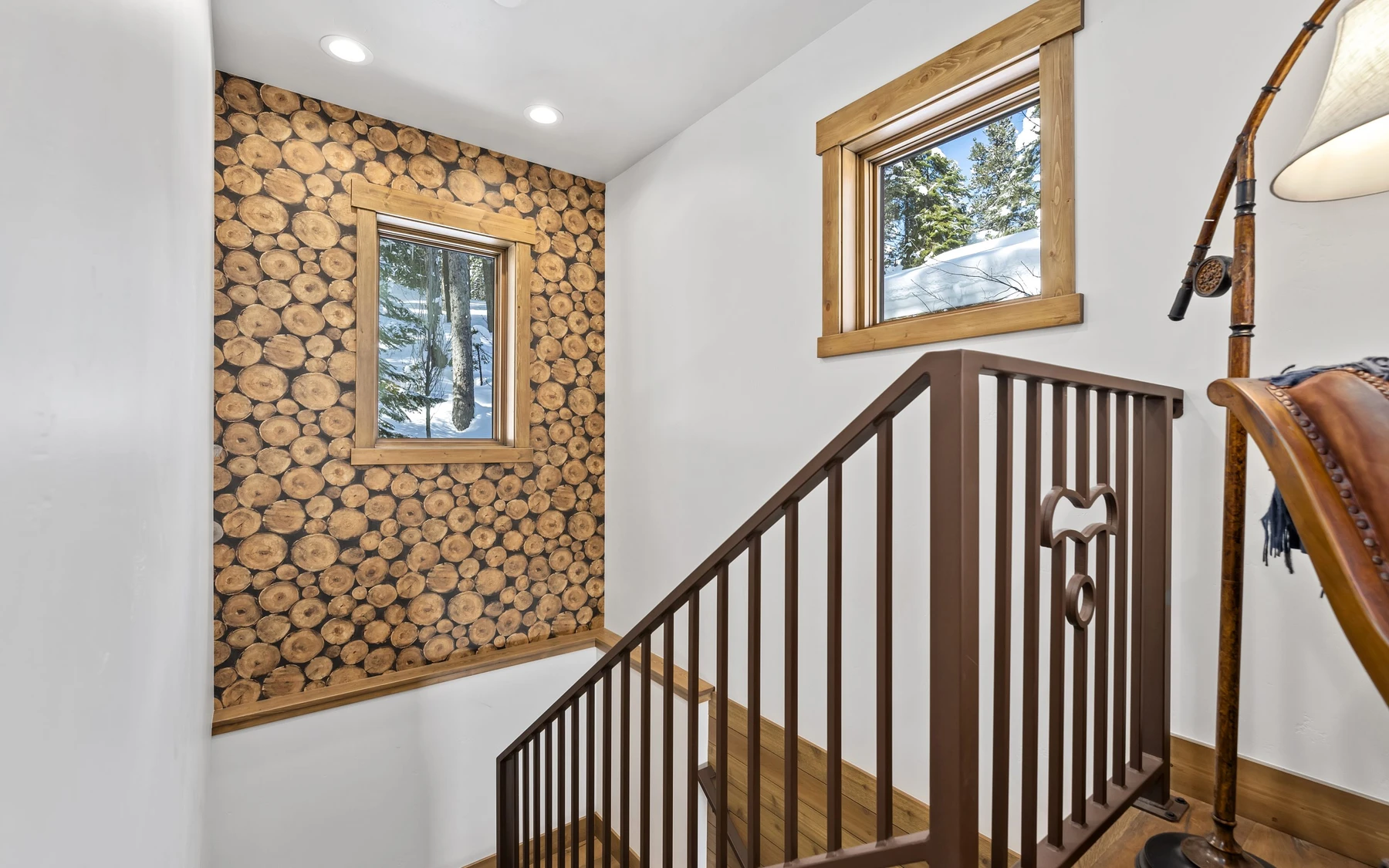 Stair hall in the Plymouth Retreat mountain home near McCall, with a custom staircase, wood railings, and natural light.