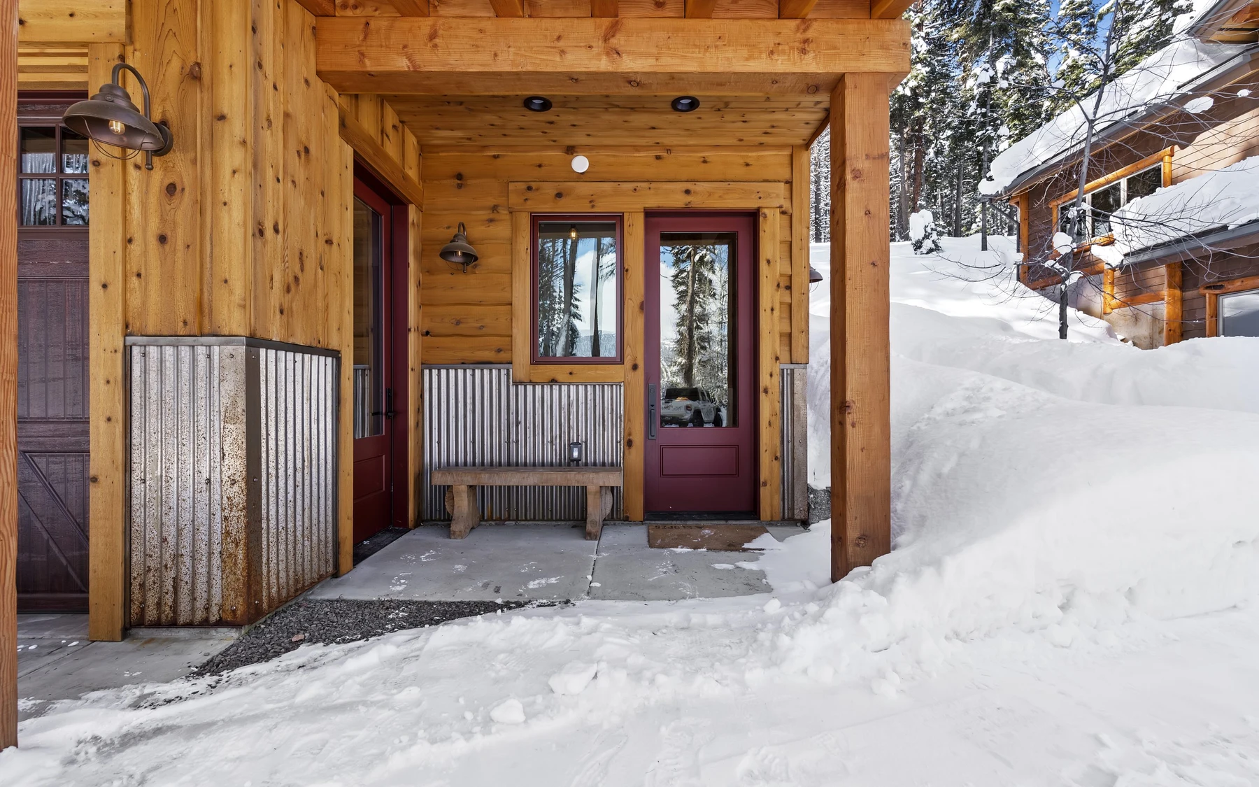 Covered outdoor space at the Plymouth Retreat mountain home near McCall, with timber details, forest views, and a winter setting.