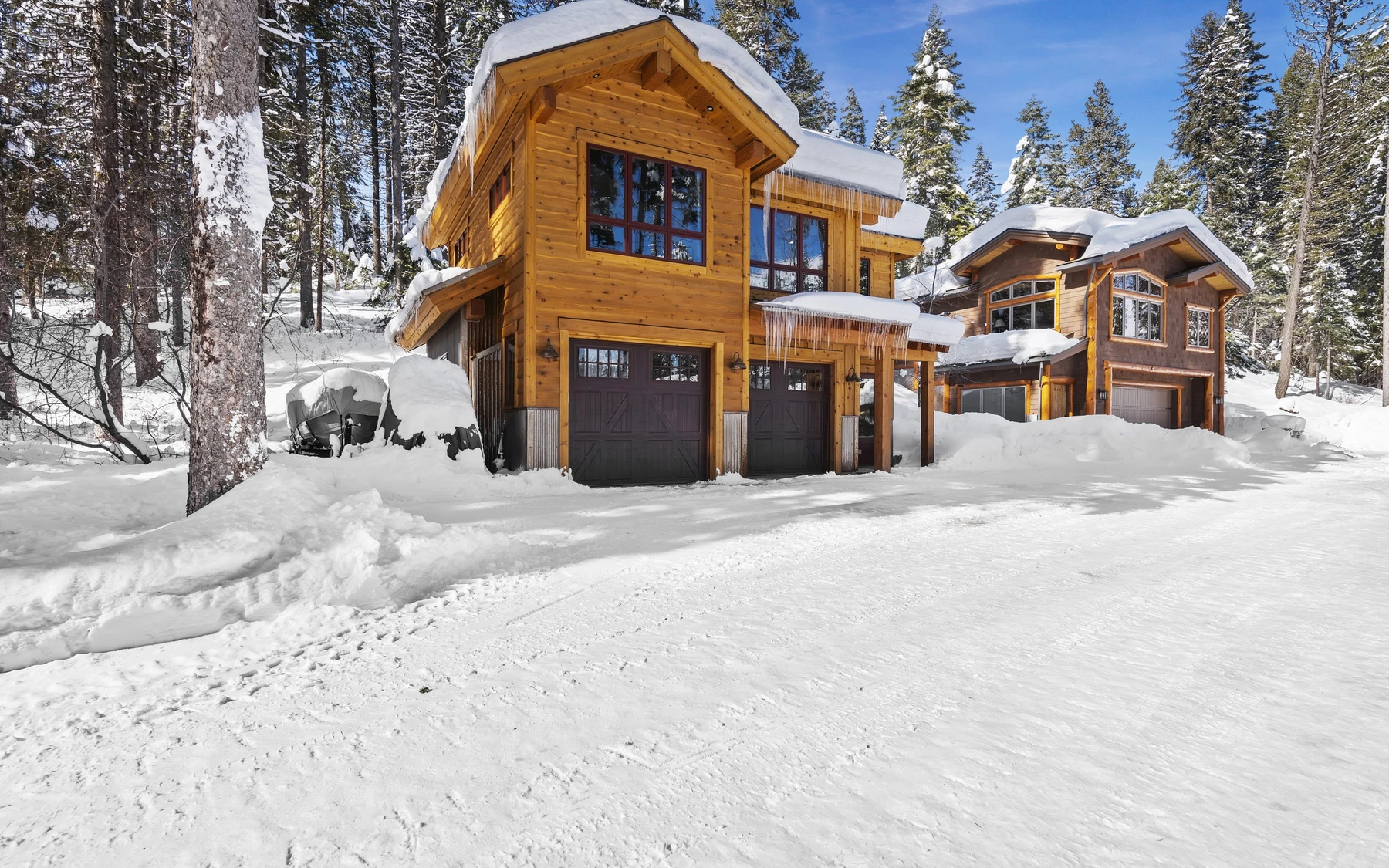Exterior of the Plymouth Retreat mountain home near McCall, showing the surrounding forest and snow-covered grounds.