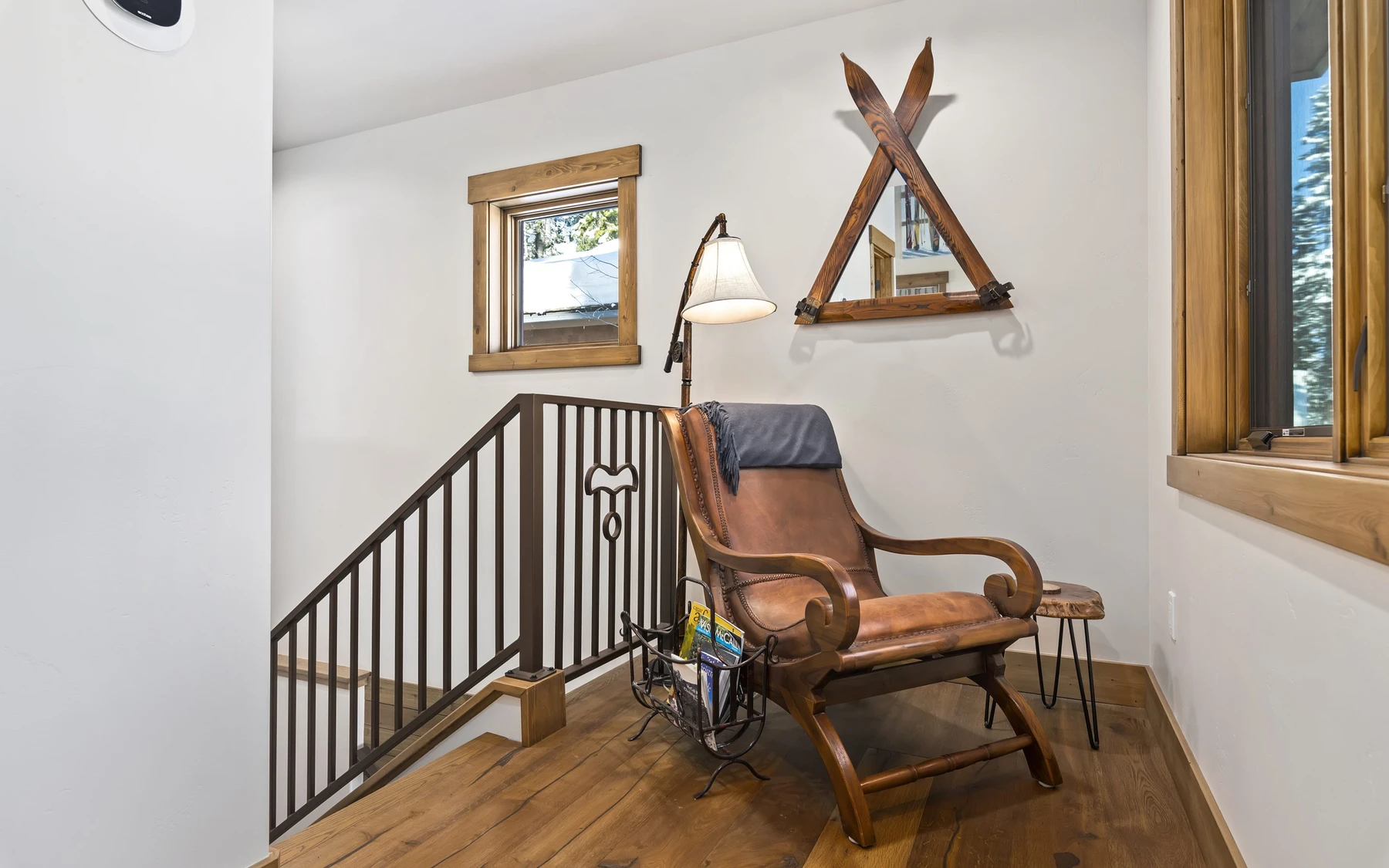 Stair hall in the Plymouth Retreat mountain home near McCall, with a custom staircase, wood railings, and natural light.