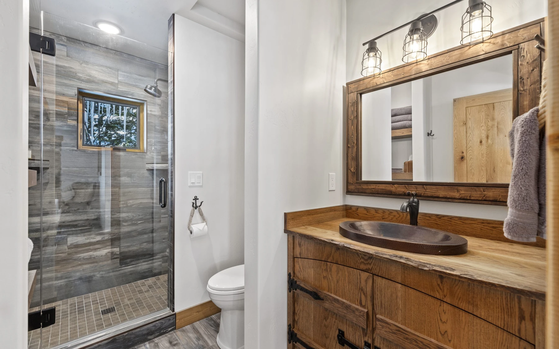 Bathroom in the Plymouth Retreat mountain home near McCall, with a custom vanity, wood cabinetry, and natural light.
