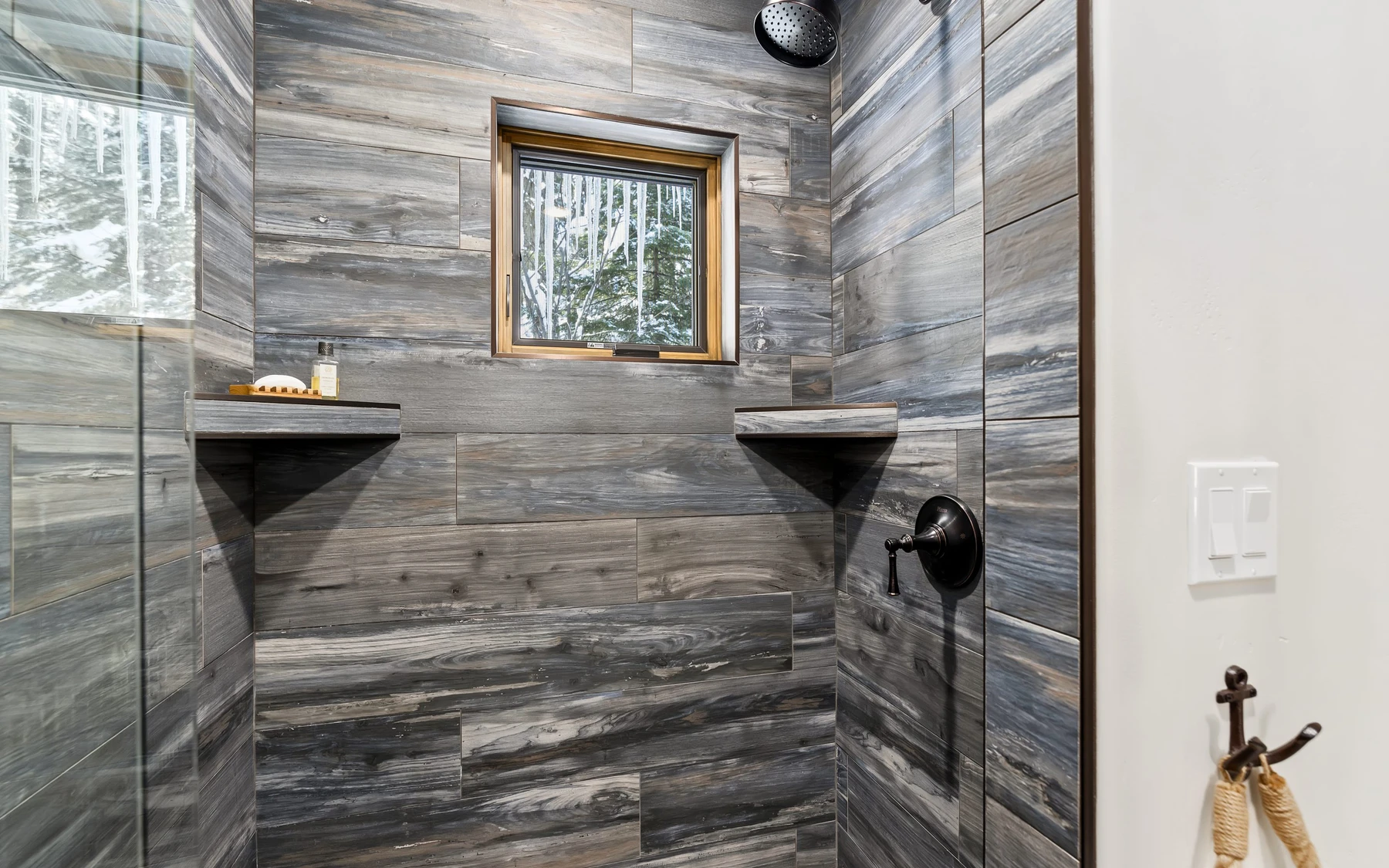 Bathroom in the Plymouth Retreat mountain home near McCall, with a glass shower, a custom vanity, and wood cabinetry.