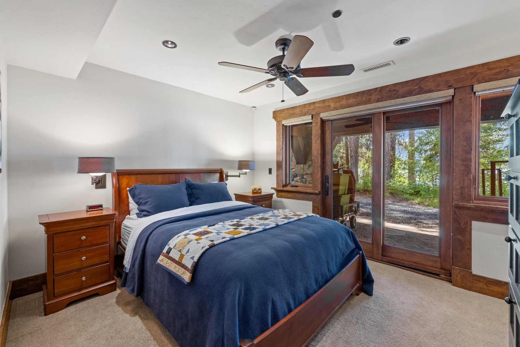 Bedroom in the Rocky Shore lakefront home on Payette Lake, with a layered bed, large windows, and wood details.