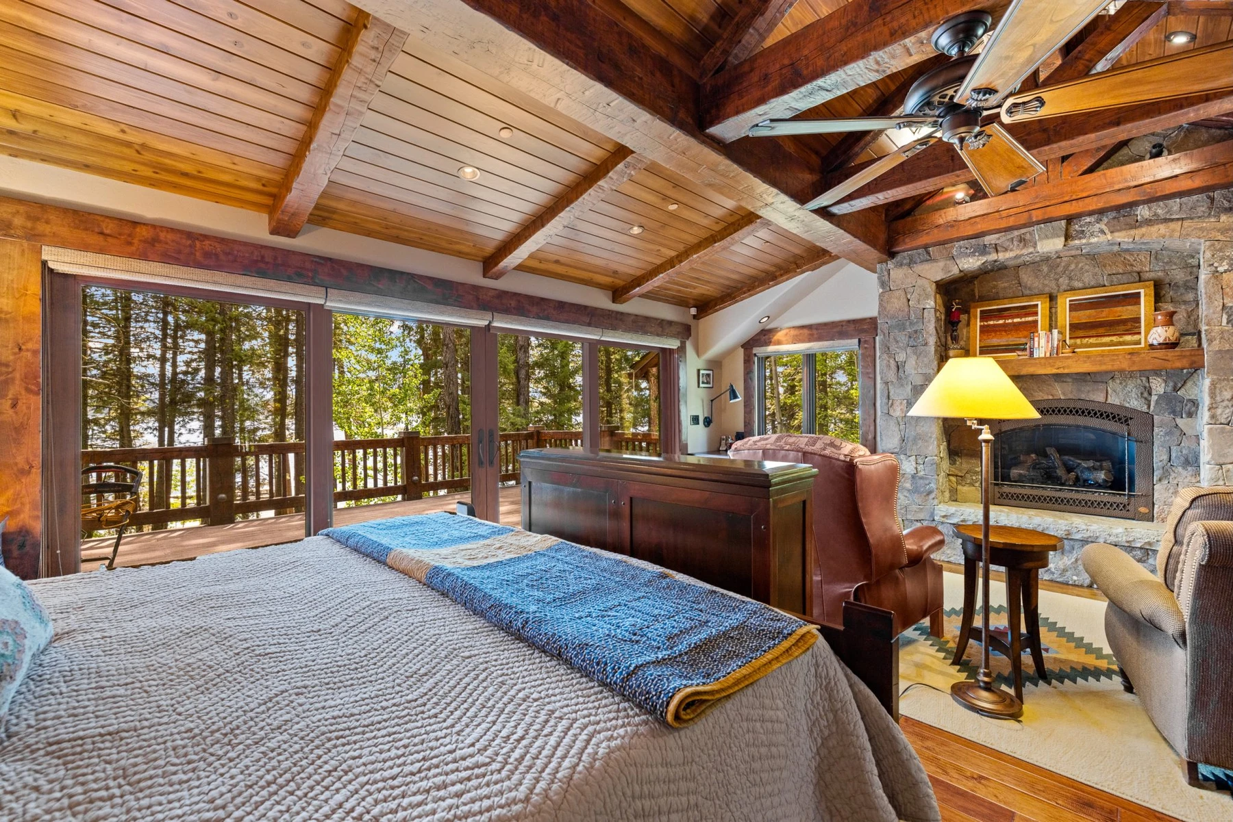 Bedroom in the Rocky Shore lakefront home on Payette Lake, with a layered bed, large windows, and wood details.