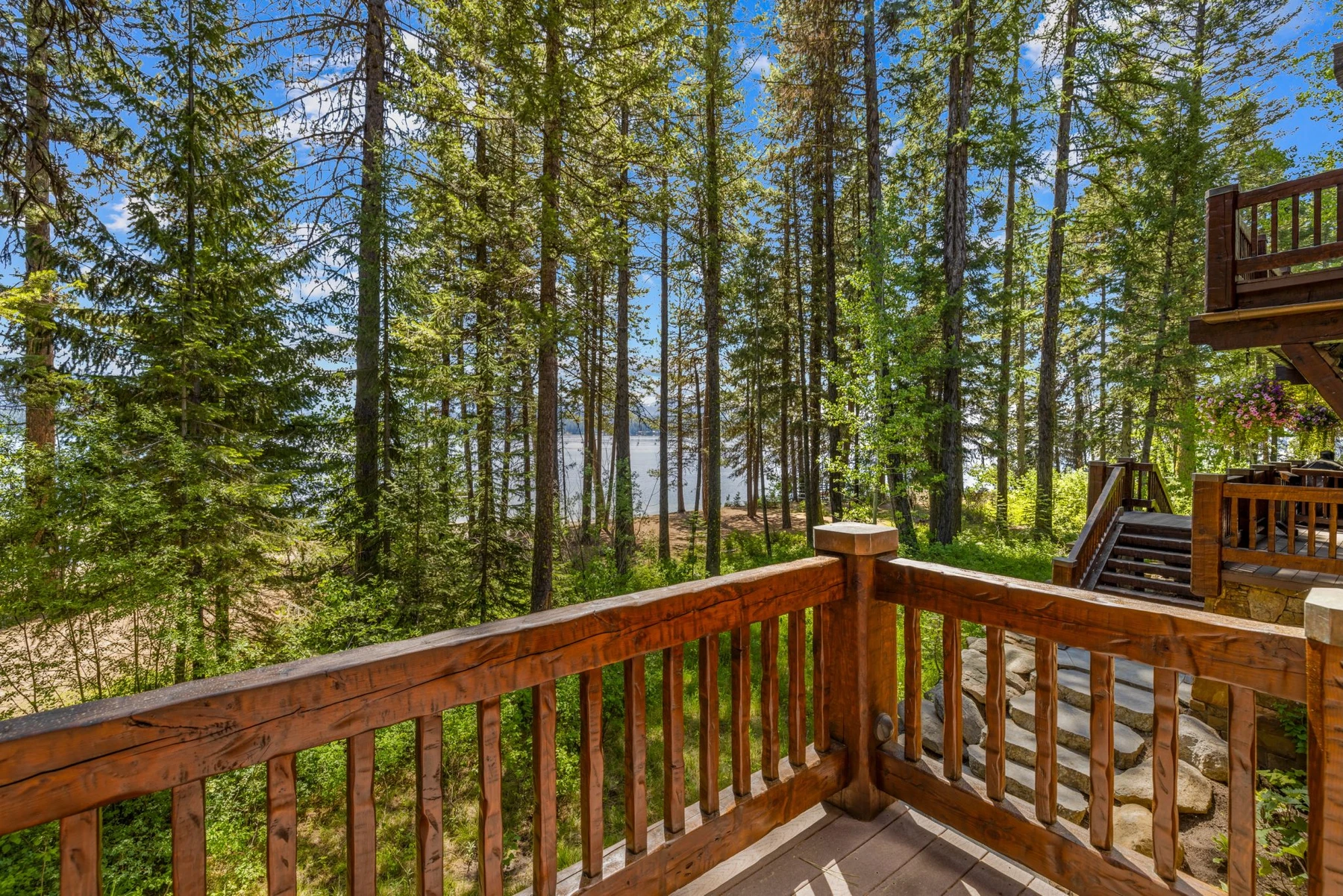 Exterior of the Rocky Shore lakefront home on Payette Lake, showing wood siding and timber details and the surrounding forest.