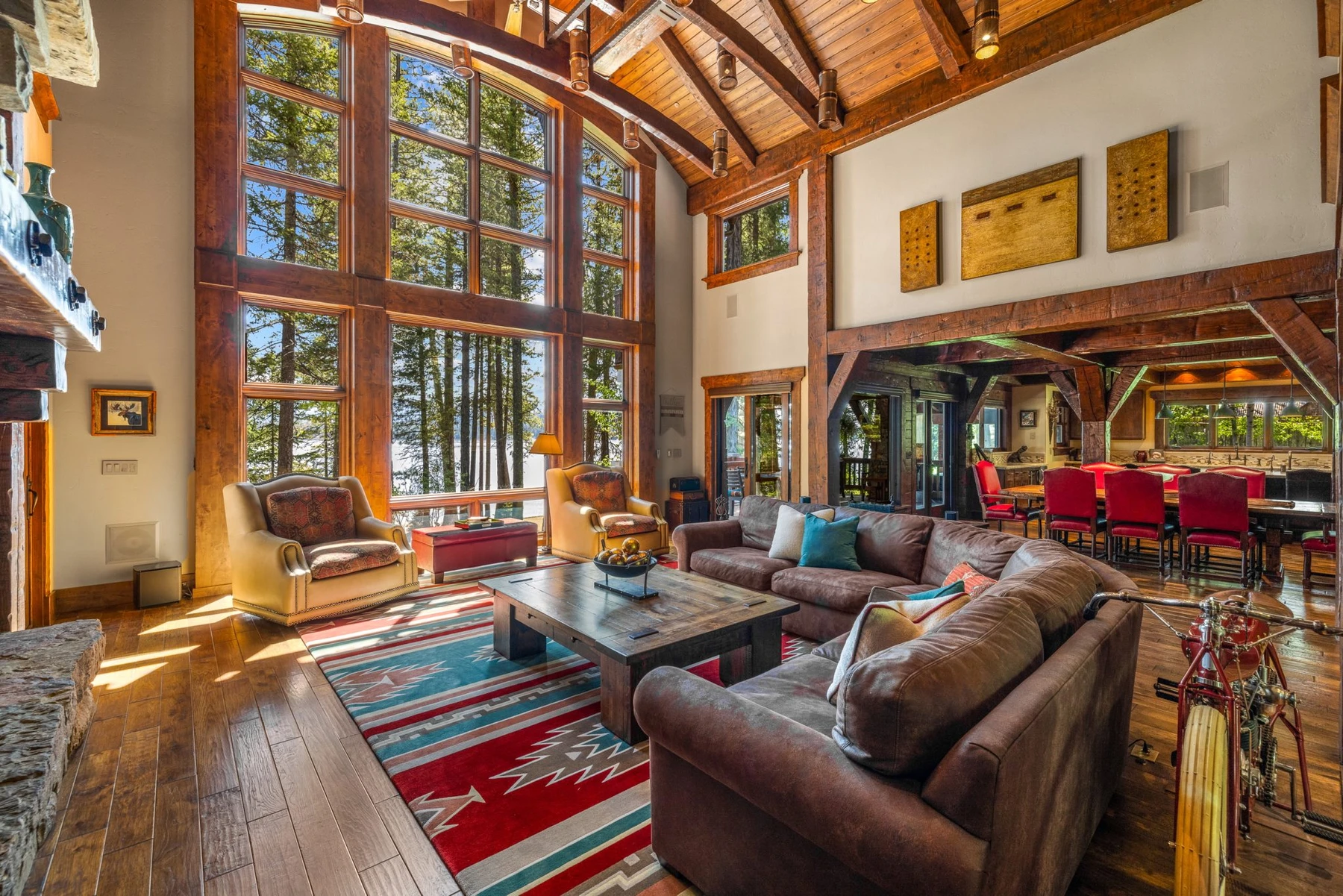 Living room in the Rocky Shore lakefront home on Payette Lake, with a relaxed seating area, large windows, and warm wood finishes.