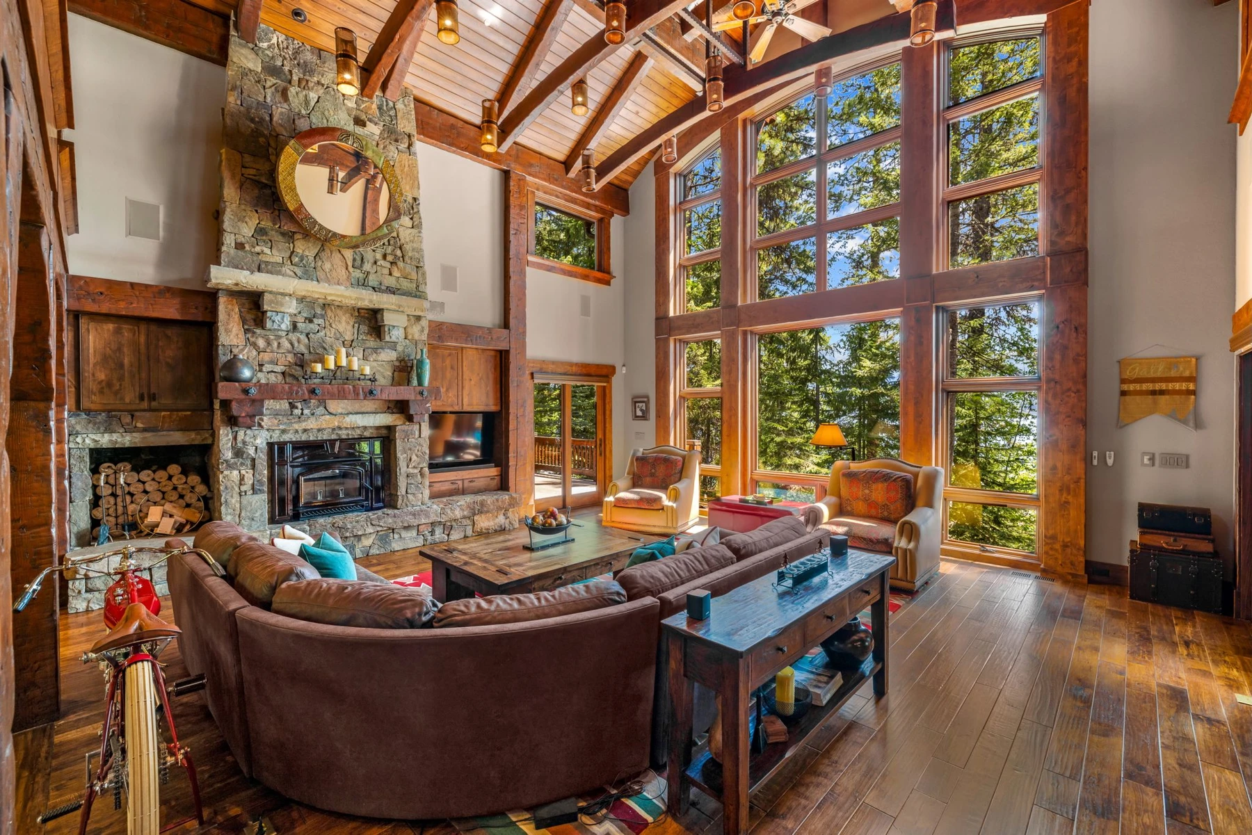 Living room in the Rocky Shore lakefront home on Payette Lake, with a fireplace, a relaxed seating area, and large windows.