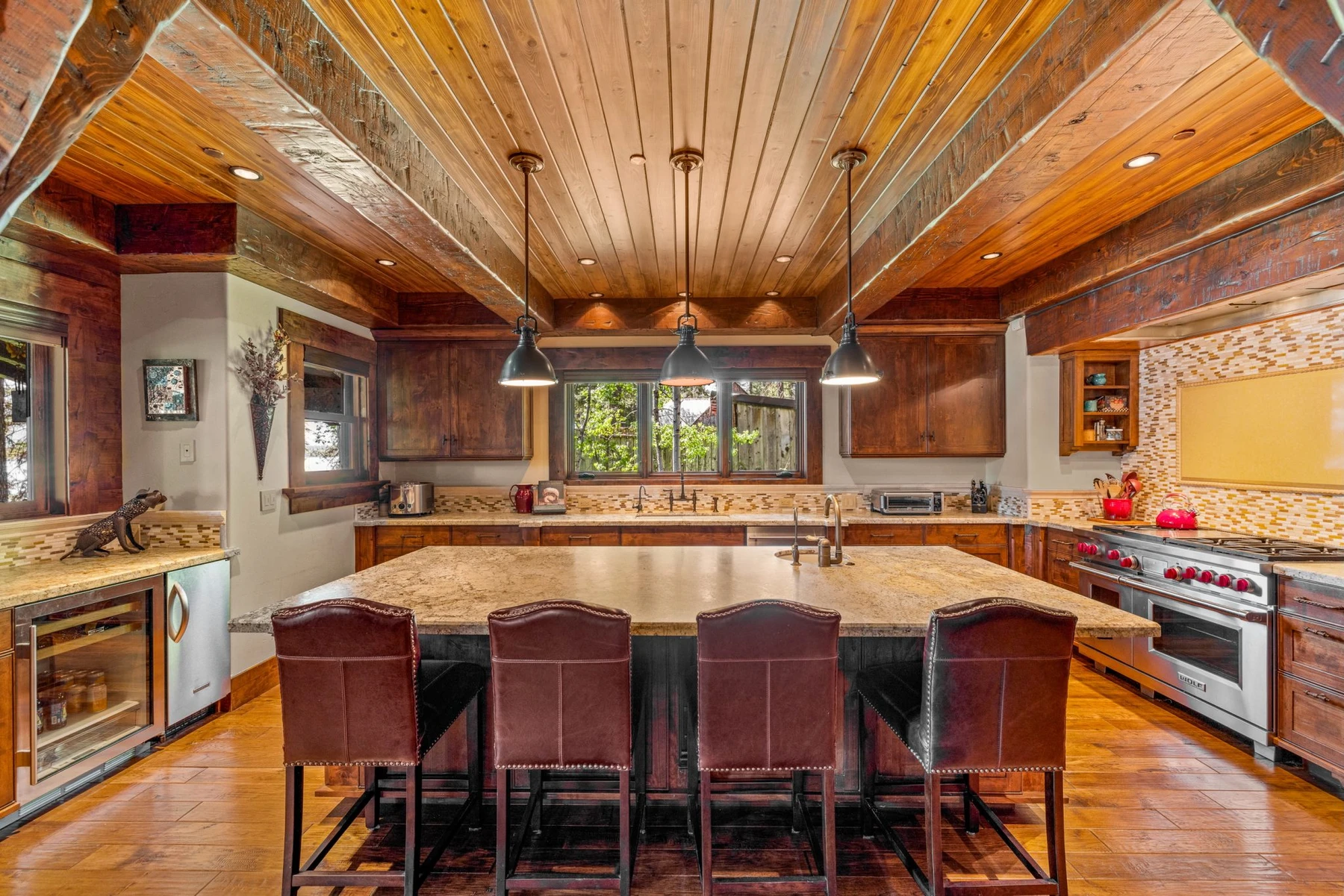 Kitchen in the Rocky Shore lakefront home on Payette Lake, with wood cabinetry, a broad countertop, and integrated appliances.