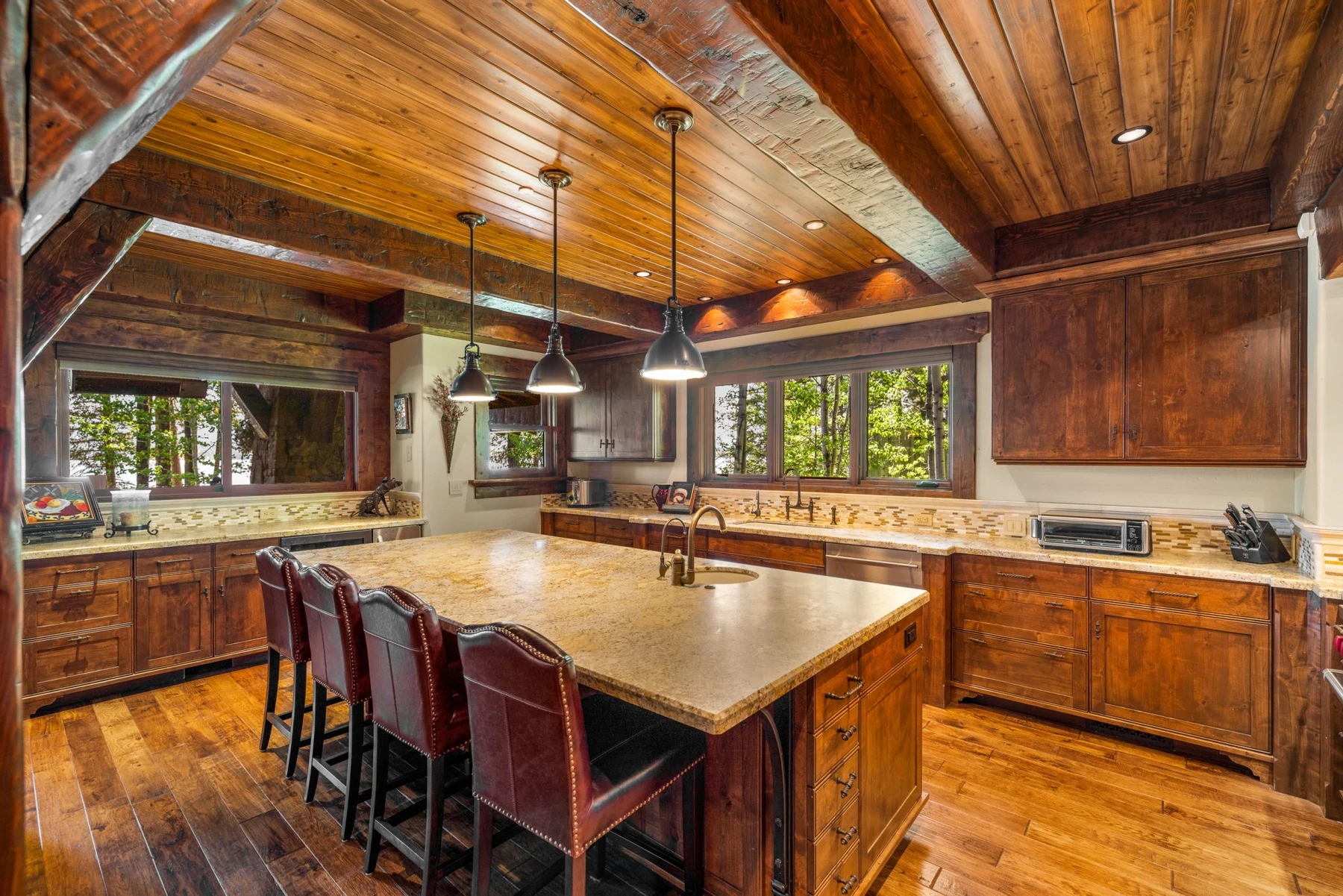 Kitchen in the Rocky Shore lakefront home on Payette Lake, with wood cabinetry, a broad countertop, and integrated appliances.