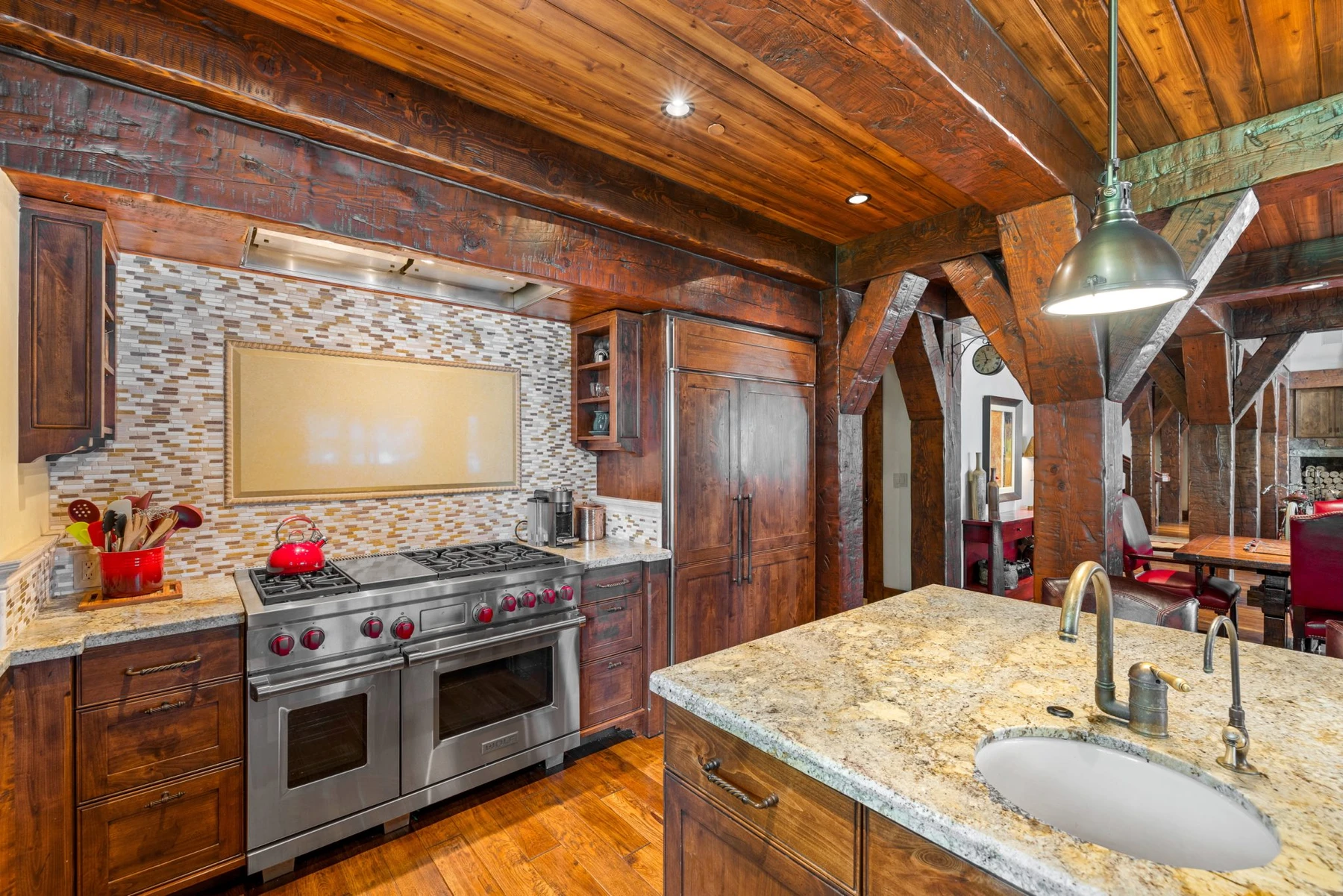 Kitchen in the Rocky Shore lakefront home on Payette Lake, with wood cabinetry, a broad countertop, and integrated appliances.