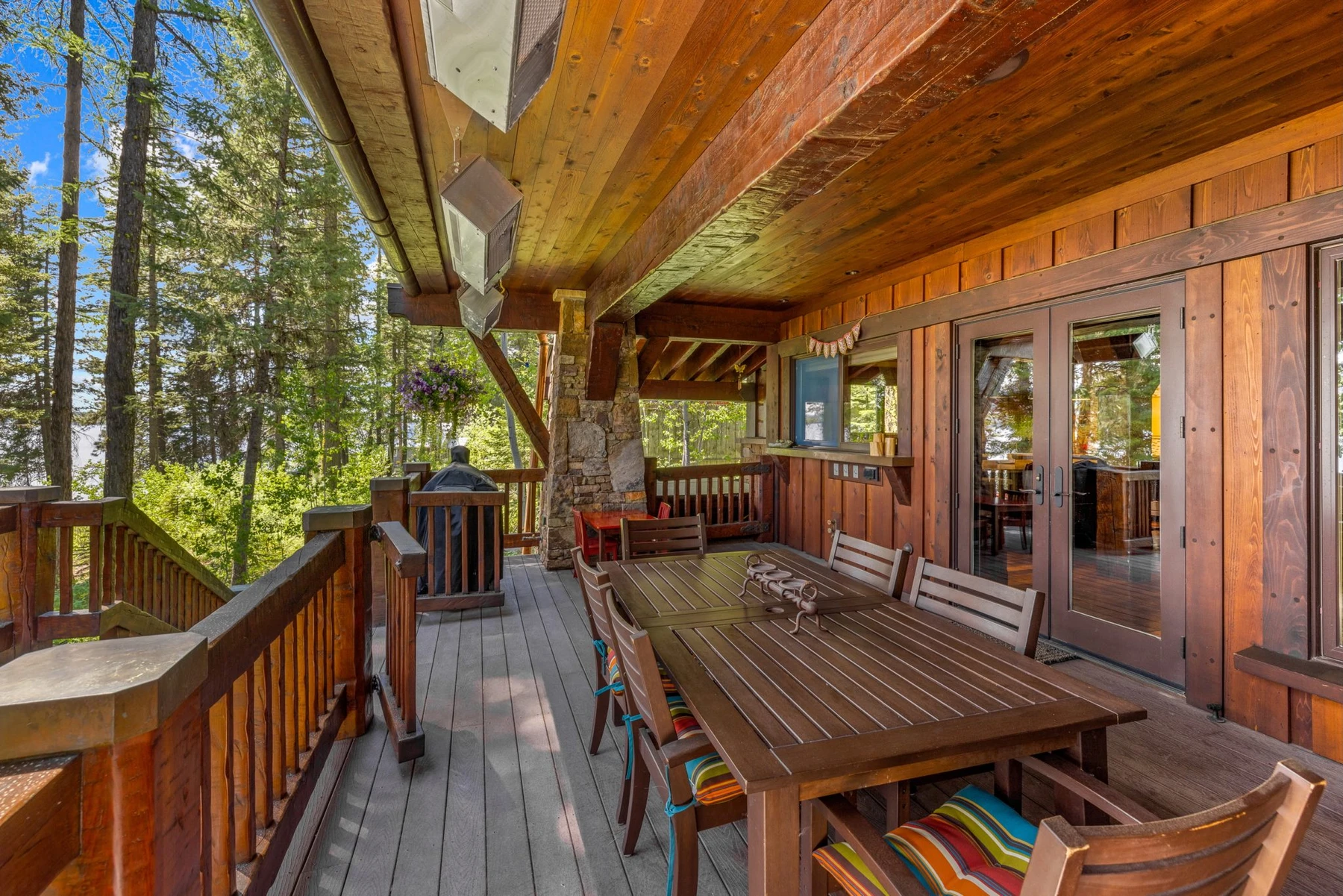 Covered outdoor space at the Rocky Shore lakefront home on Payette Lake, with outdoor seating and timber details.