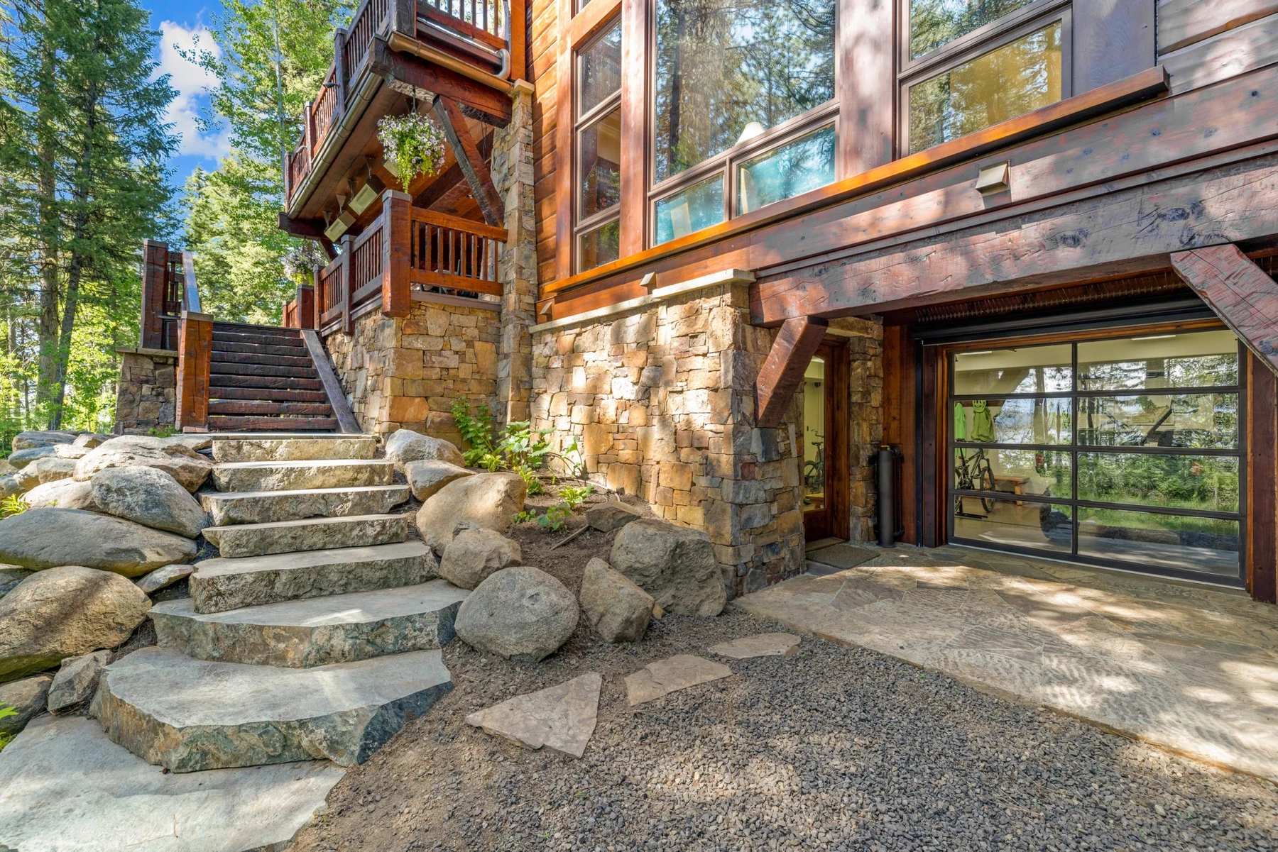 Exterior of the Rocky Shore lakefront home on Payette Lake, showing wood siding and timber details, stonework, and large windows.