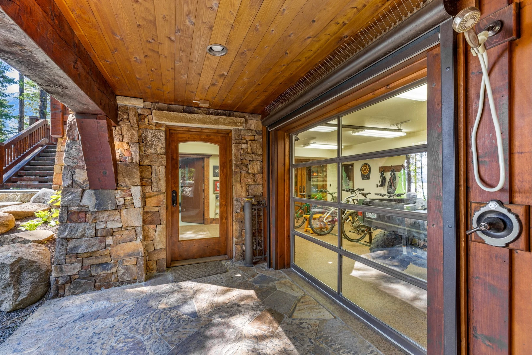 Stair hall in the Rocky Shore lakefront home on Payette Lake, with a custom staircase, wood railings, and stonework.