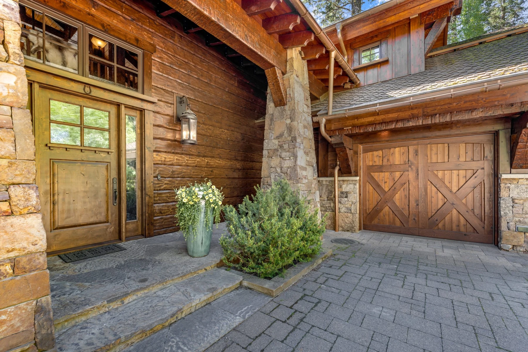 Garage approach at the Rocky Shore lakefront home on Payette Lake, with an attached garage and stone exterior details.