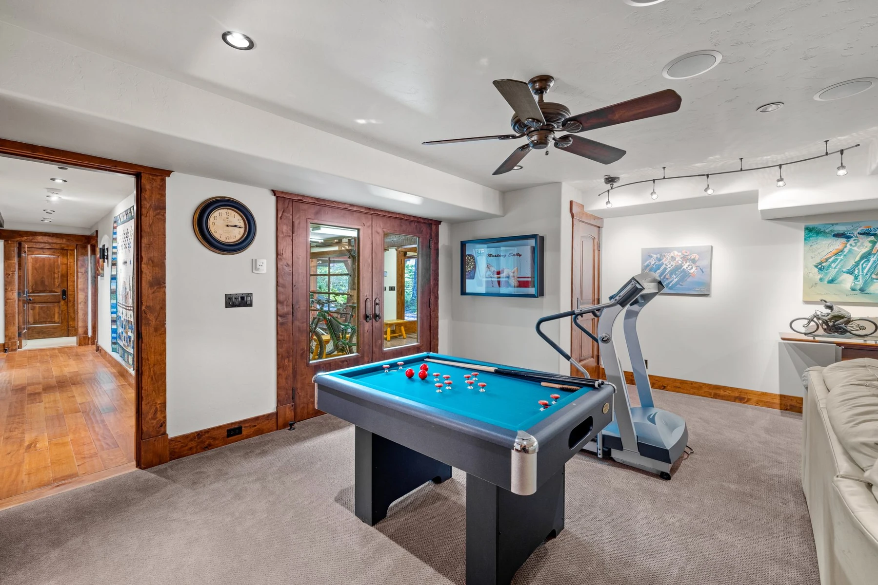 Game room in the Rocky Shore lakefront home on Payette Lake, with a billiards table, warm wood finishes, and framed artwork.