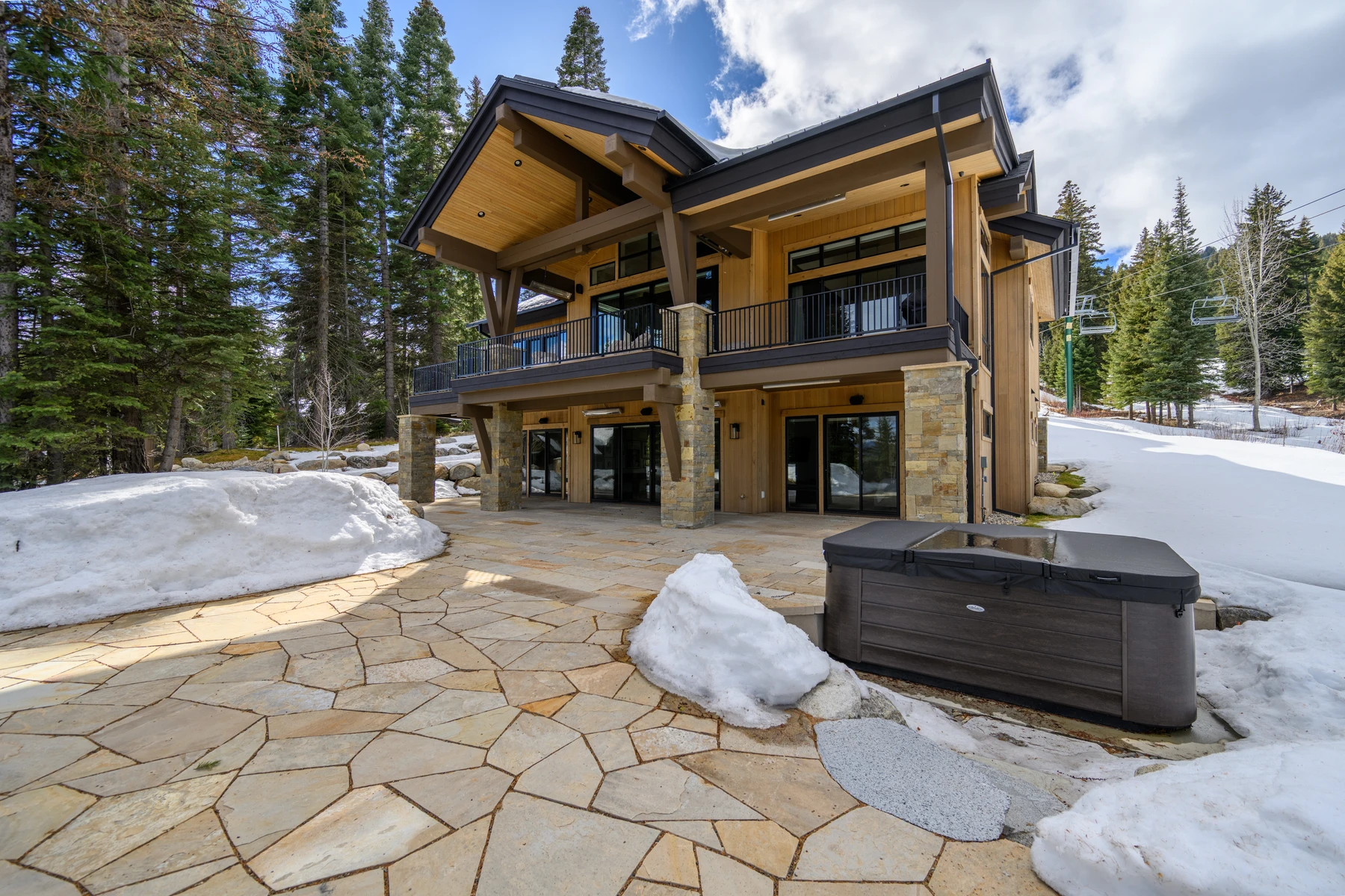 Covered outdoor space at the SlopeSide Escape ski home at Tamarack Resort, with timber details, forest views, and a winter setting.