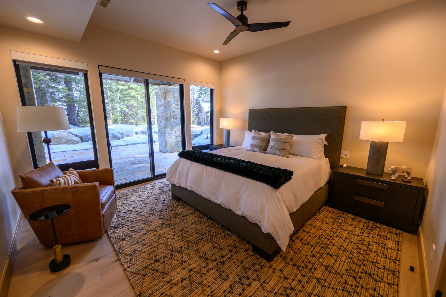 Bedroom in the SlopeSide Escape ski home at Tamarack Resort, with a layered bed, large windows, and wood details.