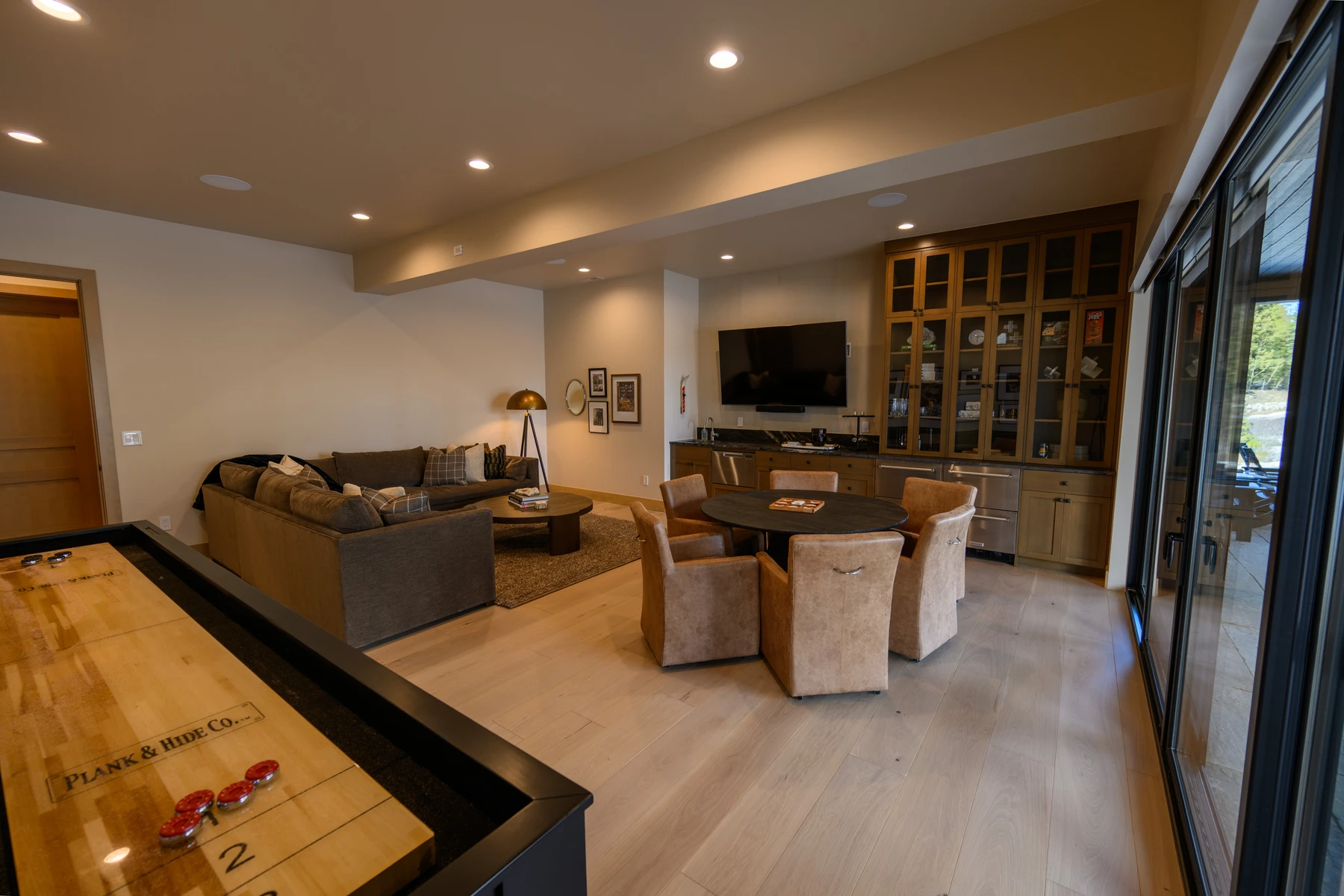 Living room in the SlopeSide Escape ski home at Tamarack Resort, with a relaxed seating area, large windows, and warm wood finishes.
