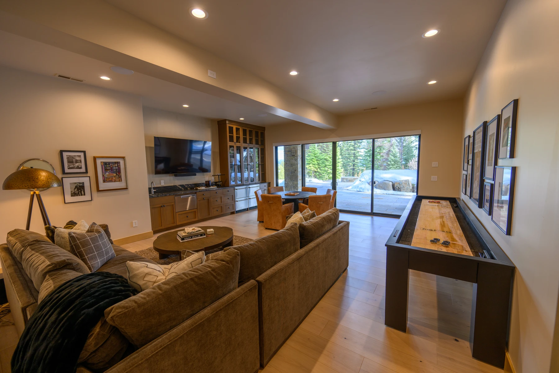 Living room in the SlopeSide Escape ski home at Tamarack Resort, with a relaxed seating area, large windows, and warm wood finishes.