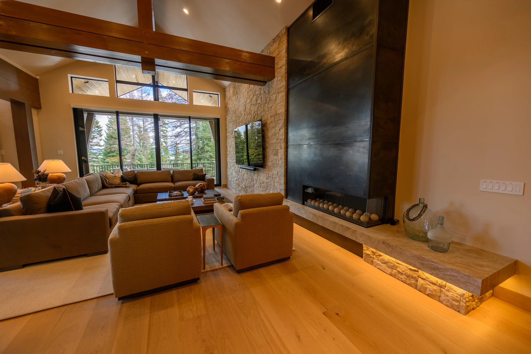 Living room in the SlopeSide Escape ski home at Tamarack Resort, with a relaxed seating area, large windows, and warm wood finishes.