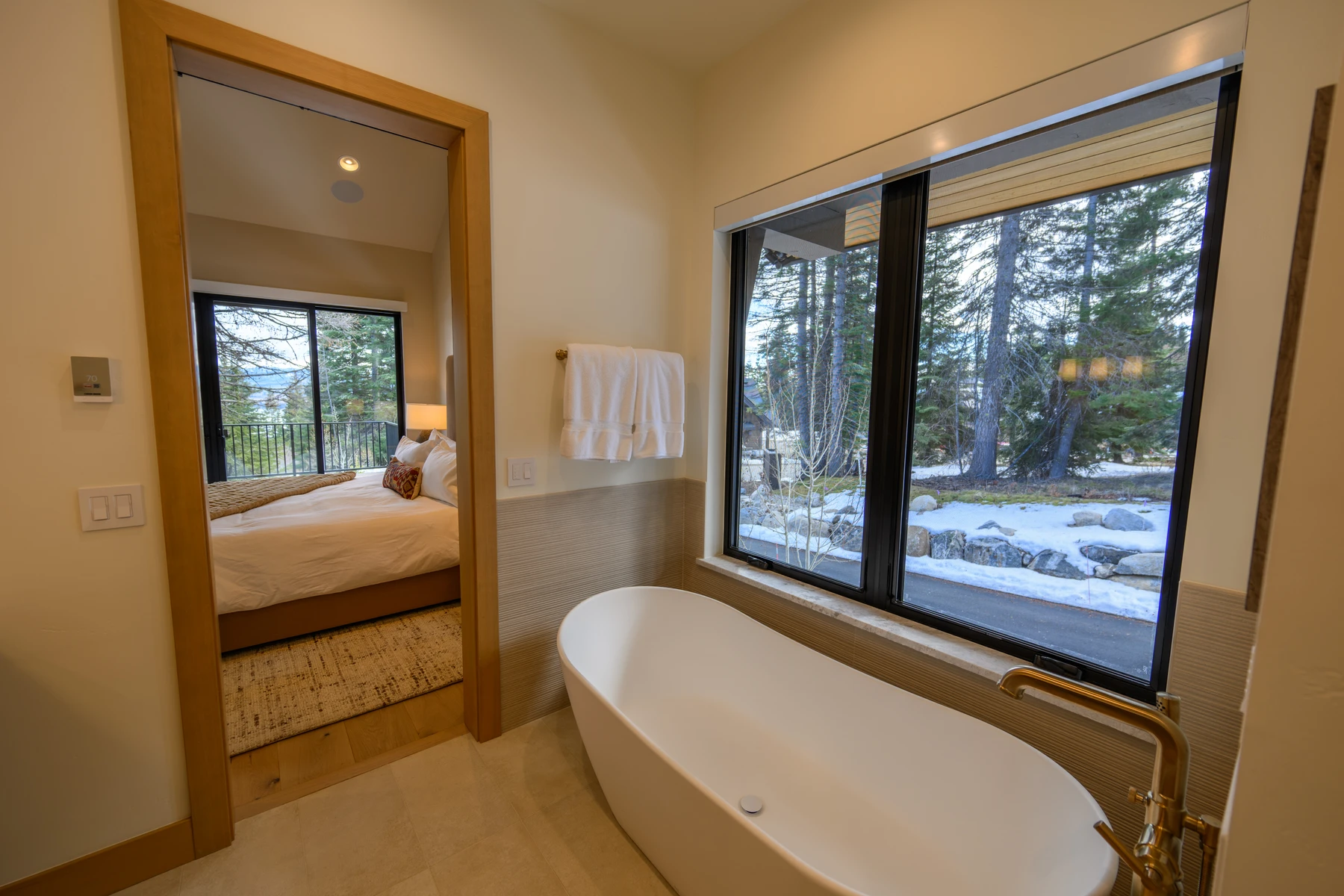 Bedroom in the SlopeSide Escape ski home at Tamarack Resort, with a layered bed, large windows, and wood details.