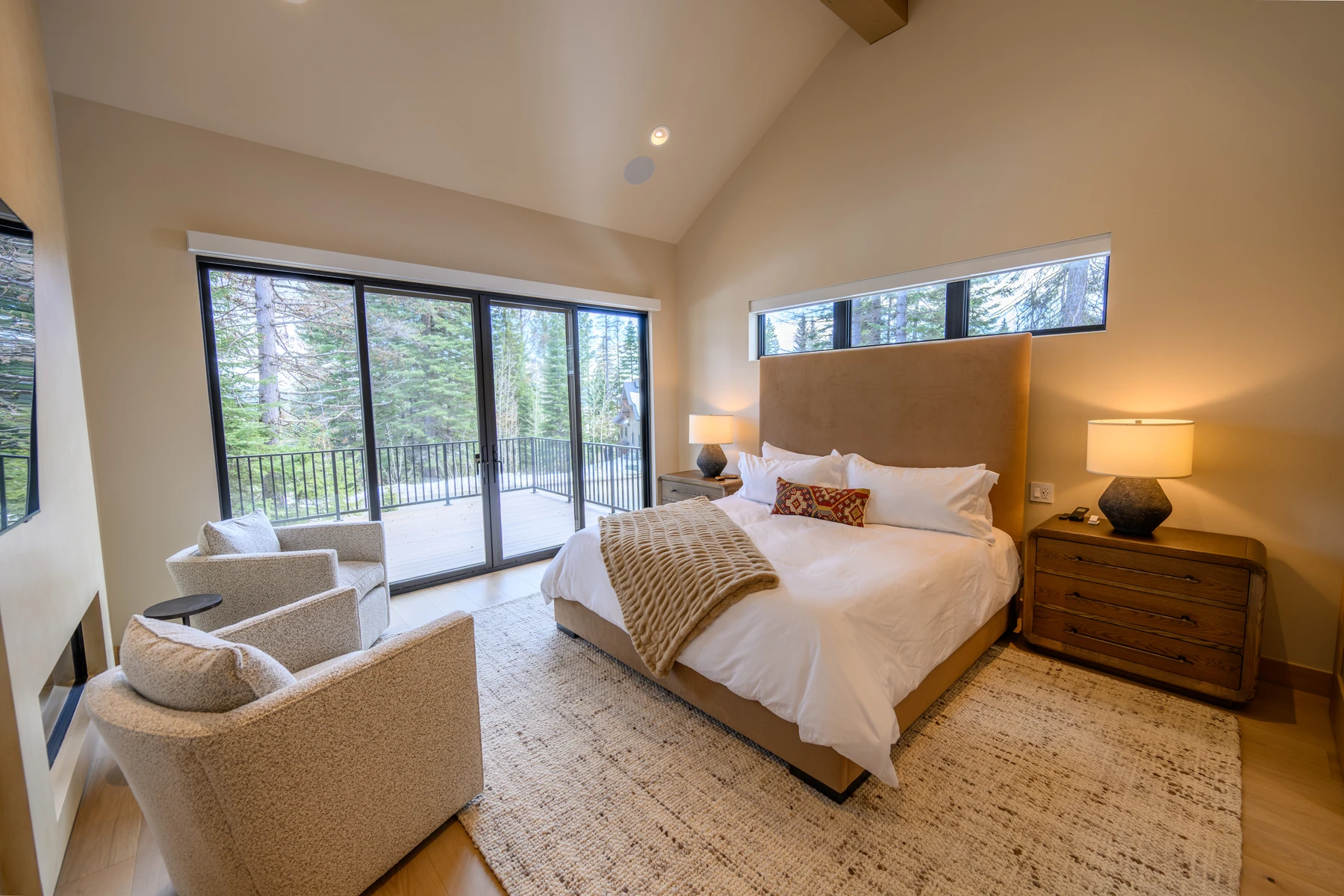 Bedroom in the SlopeSide Escape ski home at Tamarack Resort, with a layered bed, large windows, and wood details.