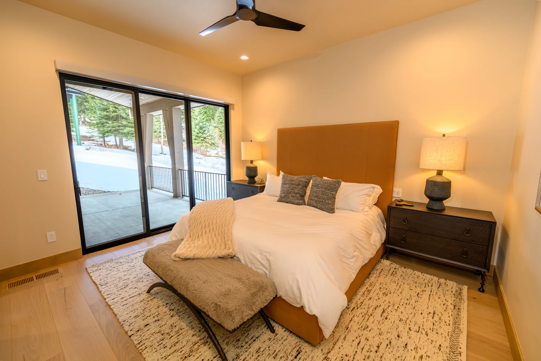 Bedroom in the SlopeSide Escape ski home at Tamarack Resort, with a layered bed, large windows, and wood details.