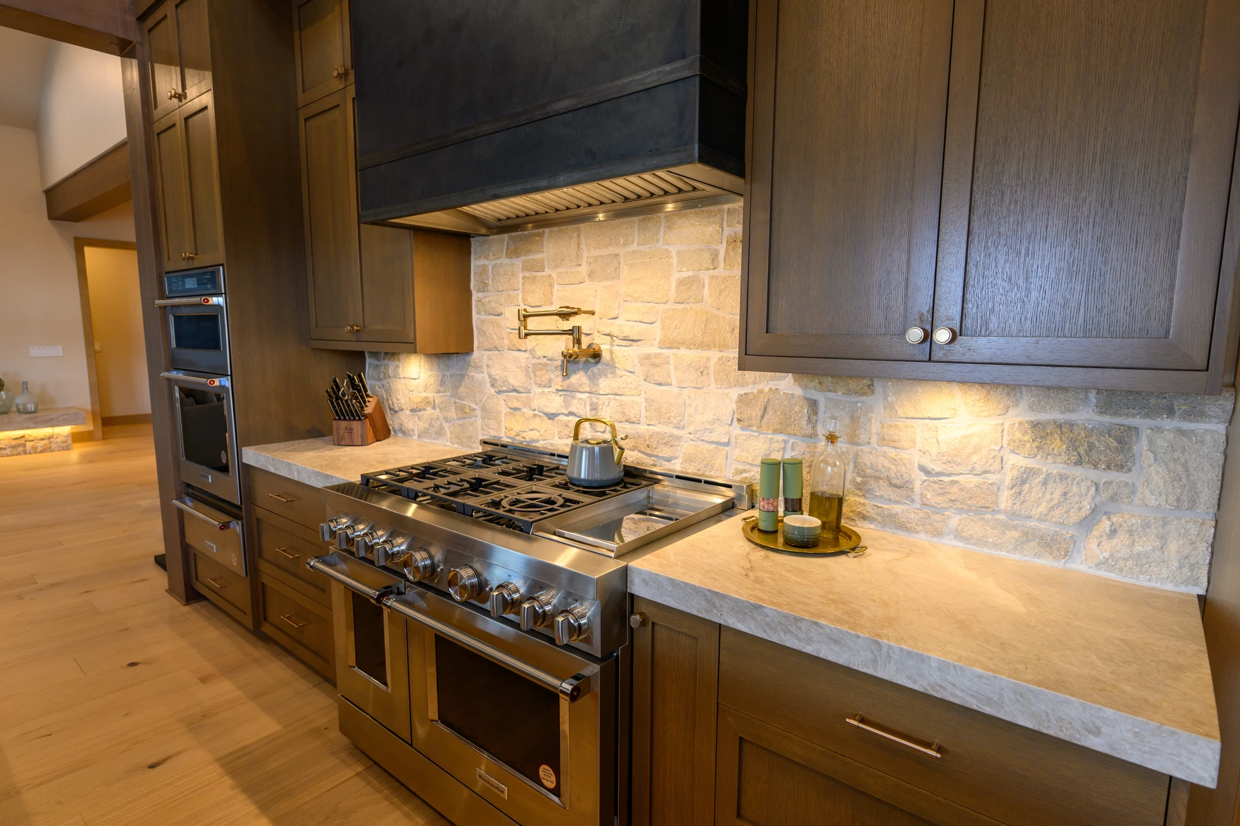 Kitchen in the SlopeSide Escape ski home at Tamarack Resort, with wood cabinetry, a broad countertop, and integrated appliances.