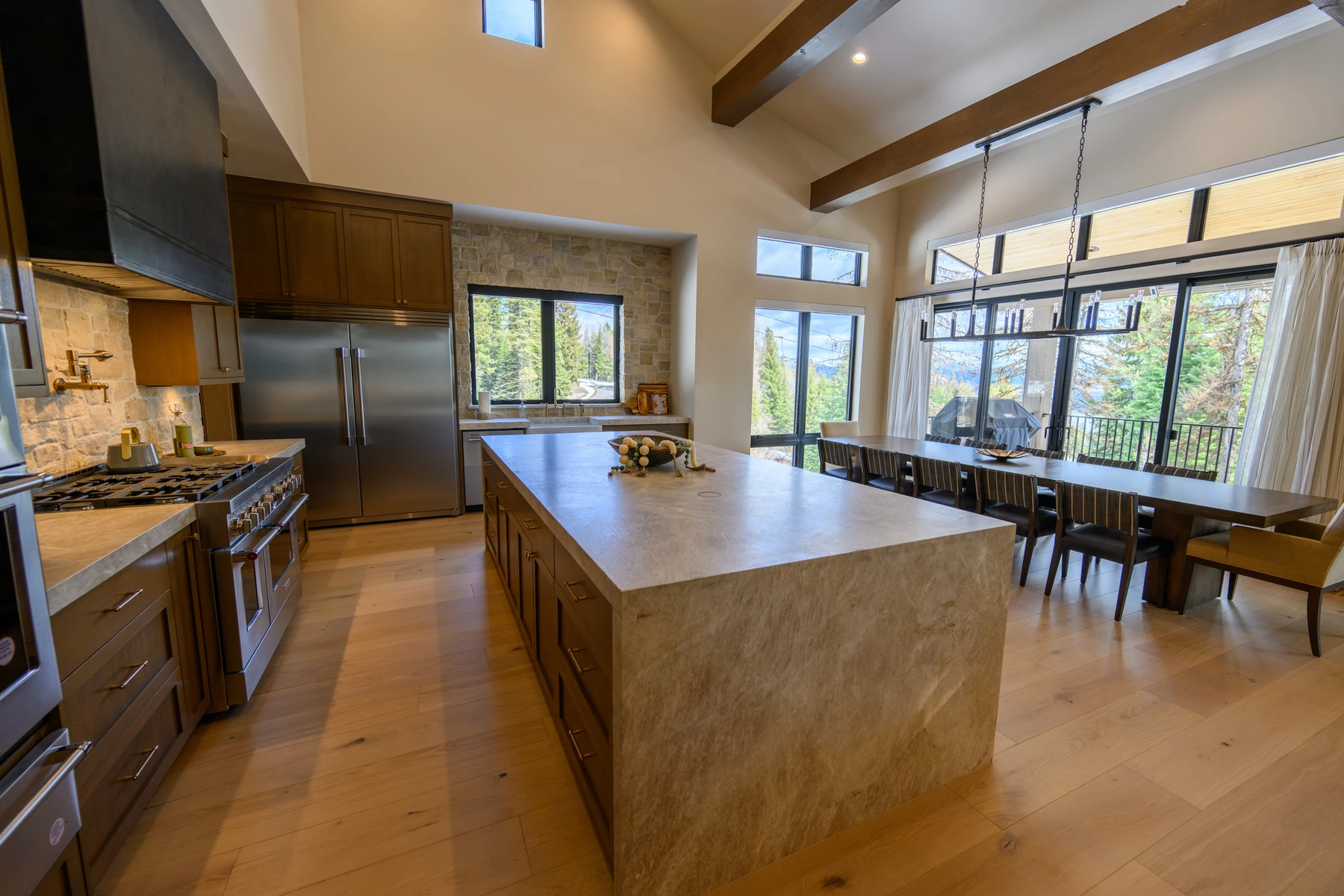 Kitchen in the SlopeSide Escape ski home at Tamarack Resort, with wood cabinetry, a broad countertop, and integrated appliances.
