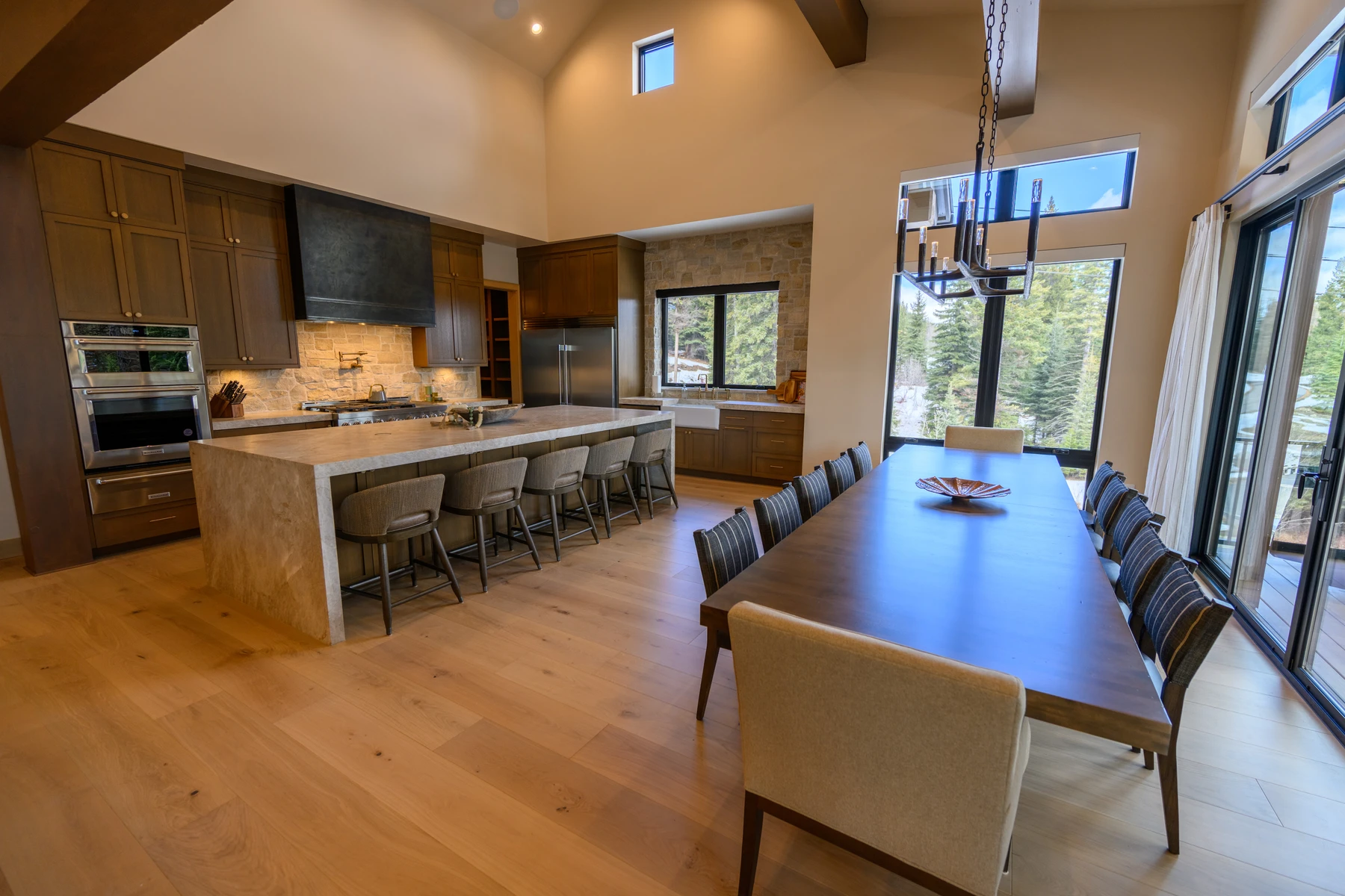 Kitchen in the SlopeSide Escape ski home at Tamarack Resort, with wood cabinetry, a broad countertop, and integrated appliances.