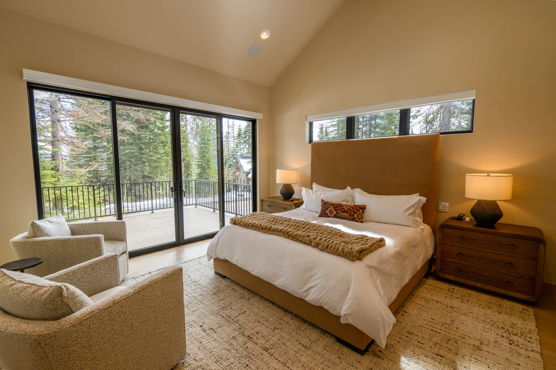 Bedroom in the SlopeSide Escape ski home at Tamarack Resort, with a layered bed, large windows, and wood details.
