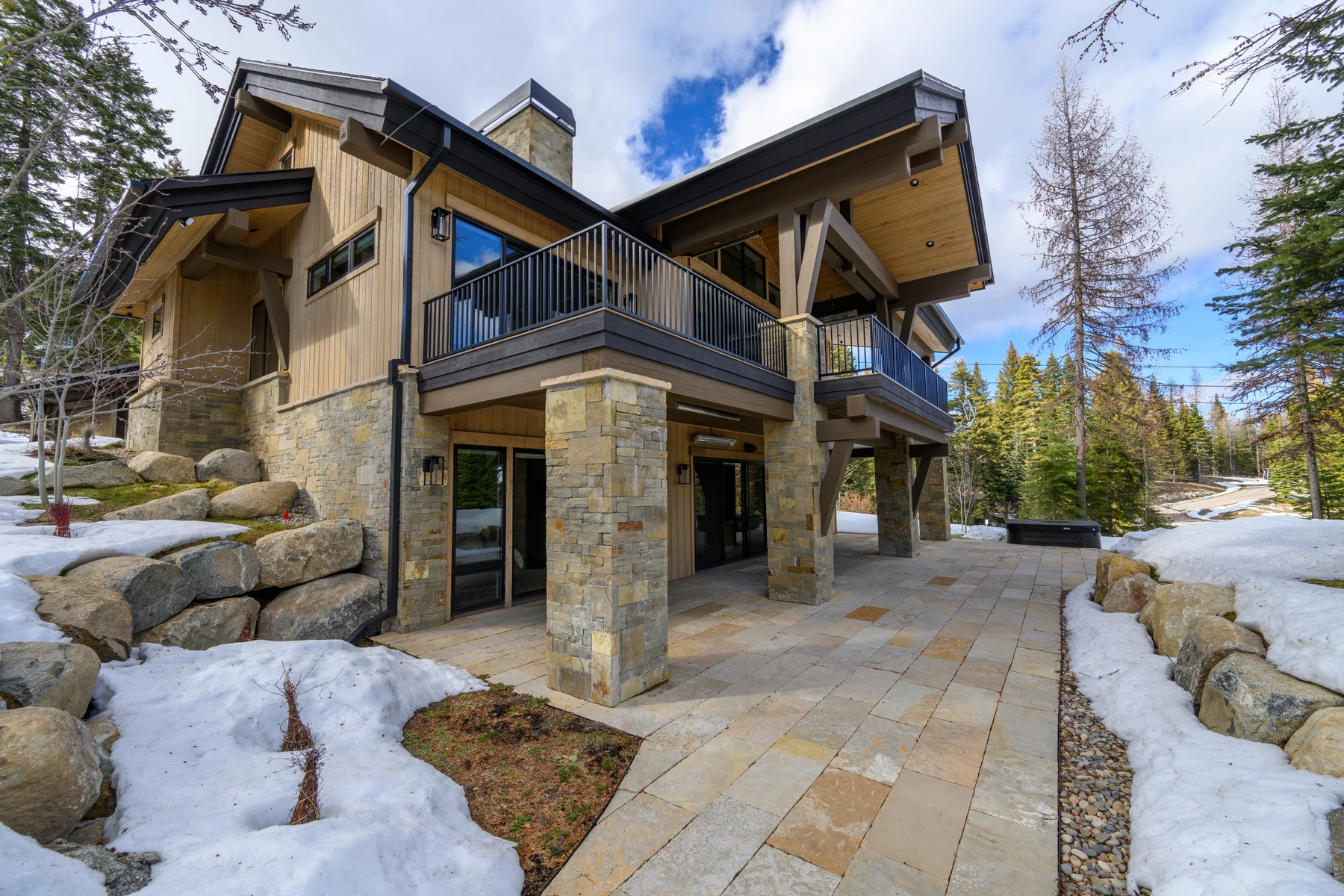 Covered outdoor space at the SlopeSide Escape ski home at Tamarack Resort, with forest views and a winter setting.