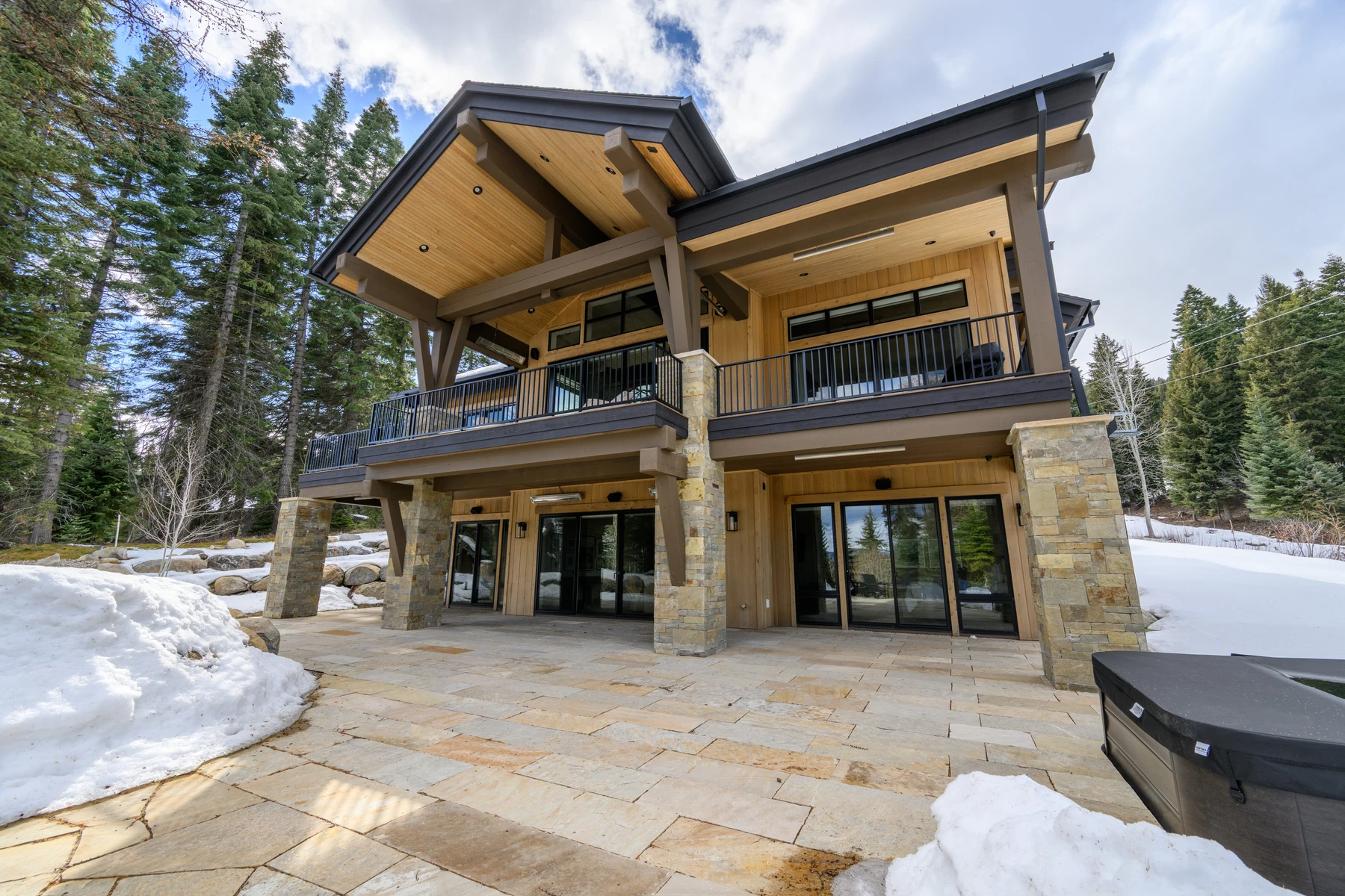 Covered outdoor space at the SlopeSide Escape ski home at Tamarack Resort, with timber details, forest views, and a winter setting.