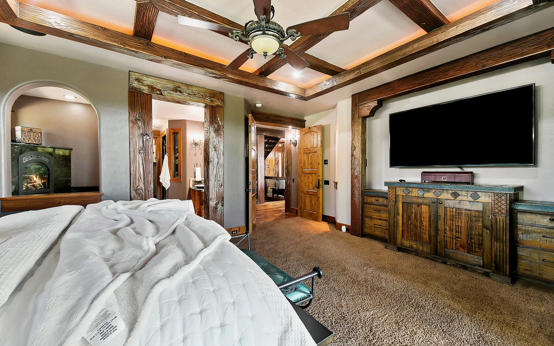 Bedroom in the Summit Sanctuary ridgeline home near McCall, with a layered bed and wood details.