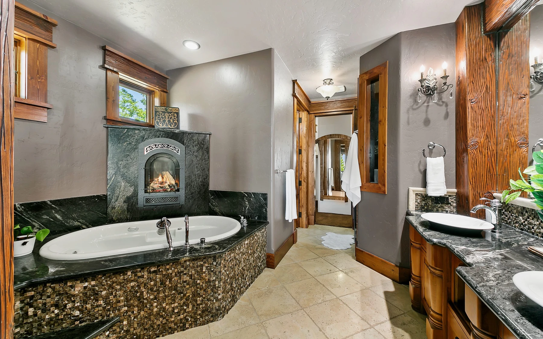 Bathroom in the Summit Sanctuary ridgeline home near McCall, with a soaking tub, a custom vanity, and wood cabinetry.
