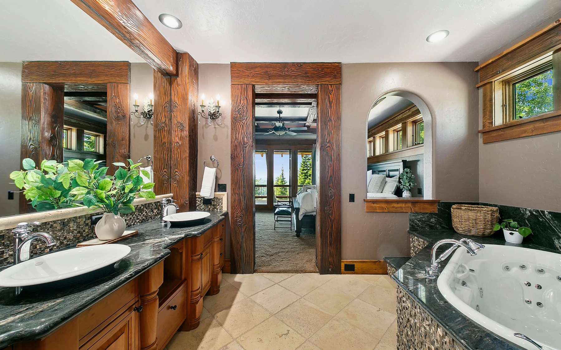 Bathroom in the Summit Sanctuary ridgeline home near McCall, with a soaking tub, a custom vanity, and wood cabinetry.