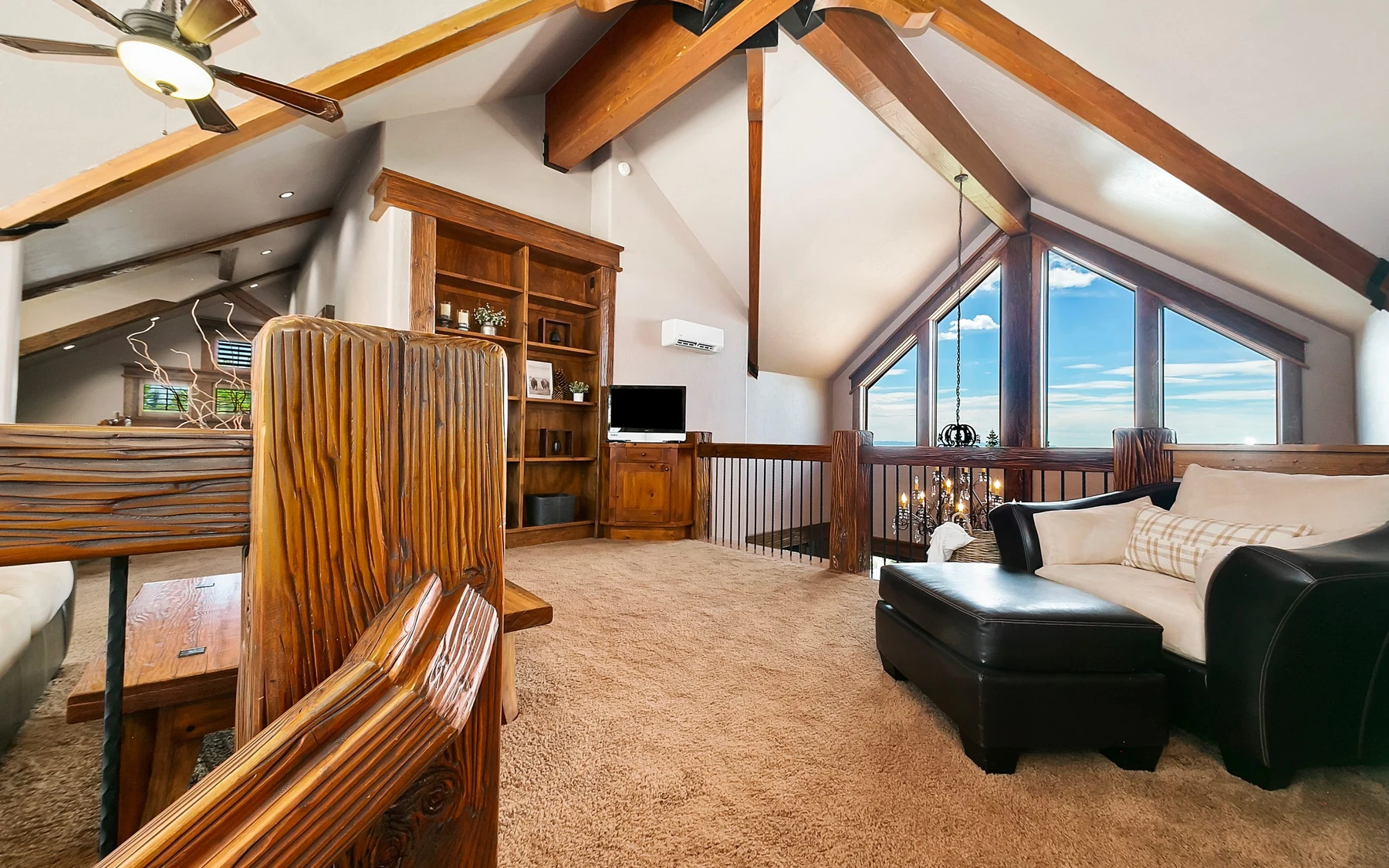 Living room in the Summit Sanctuary ridgeline home near McCall, with a relaxed seating area, large windows, and warm wood finishes.