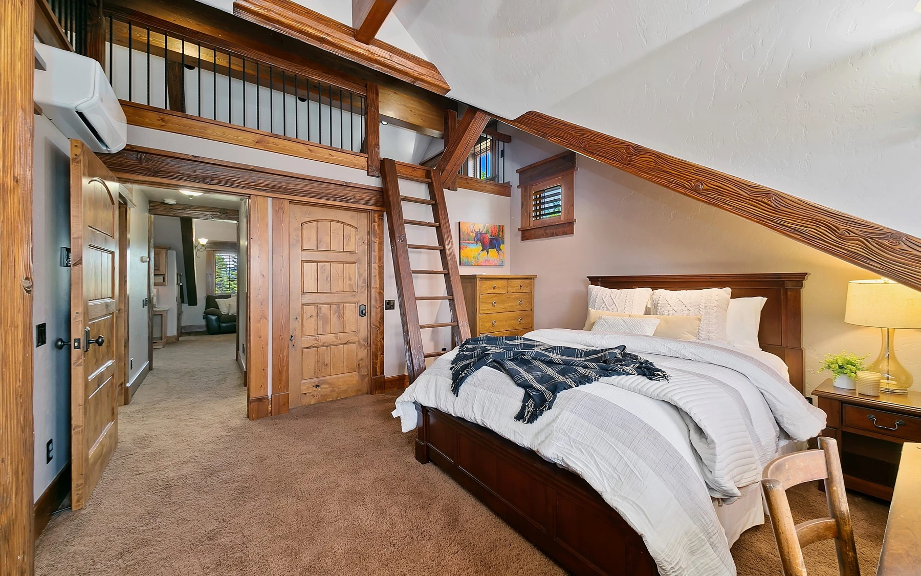 Bedroom in the Summit Sanctuary ridgeline home near McCall, with a layered bed and wood details.