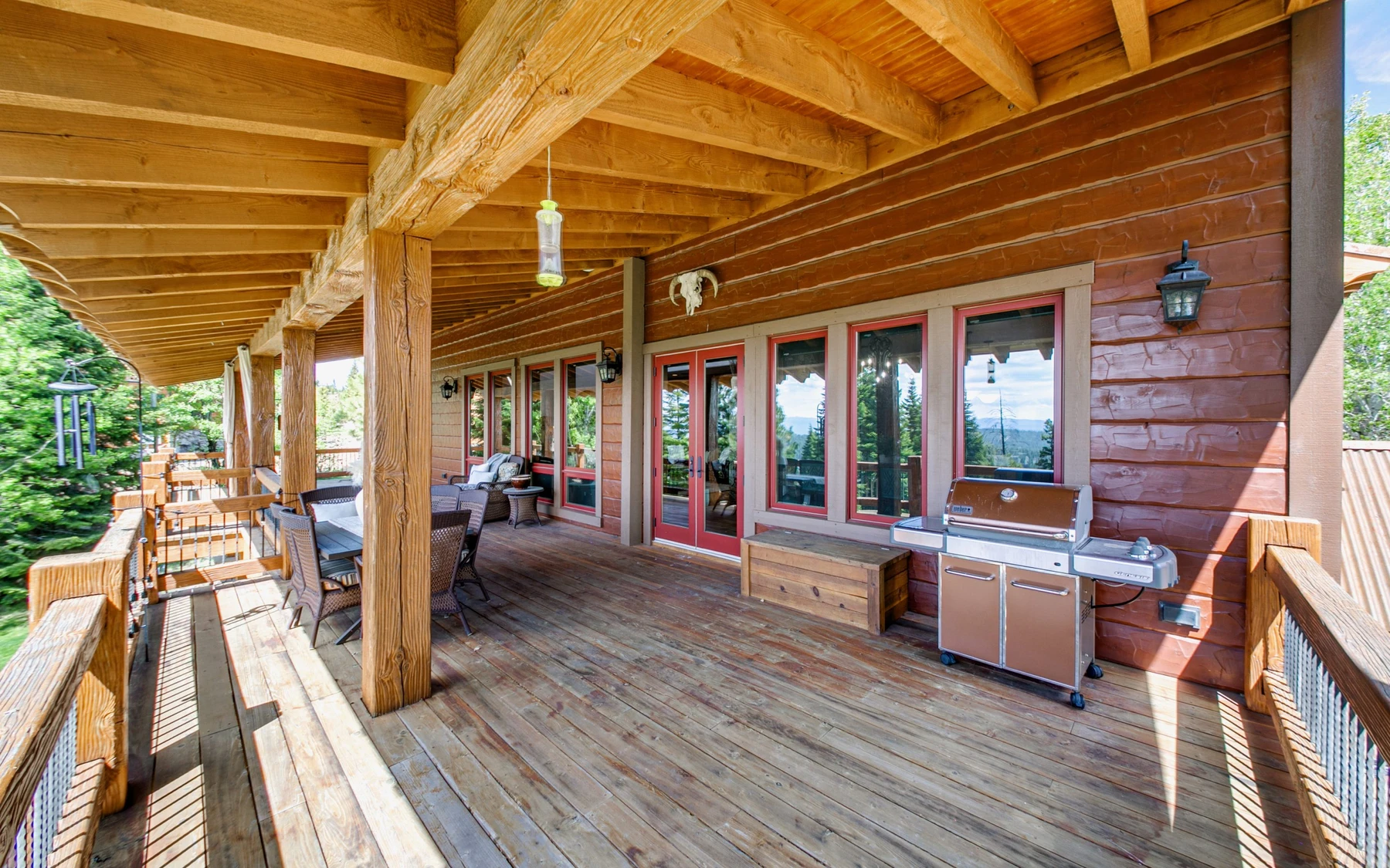 Covered outdoor space at the Summit Sanctuary ridgeline home near McCall, with outdoor seating and timber details.