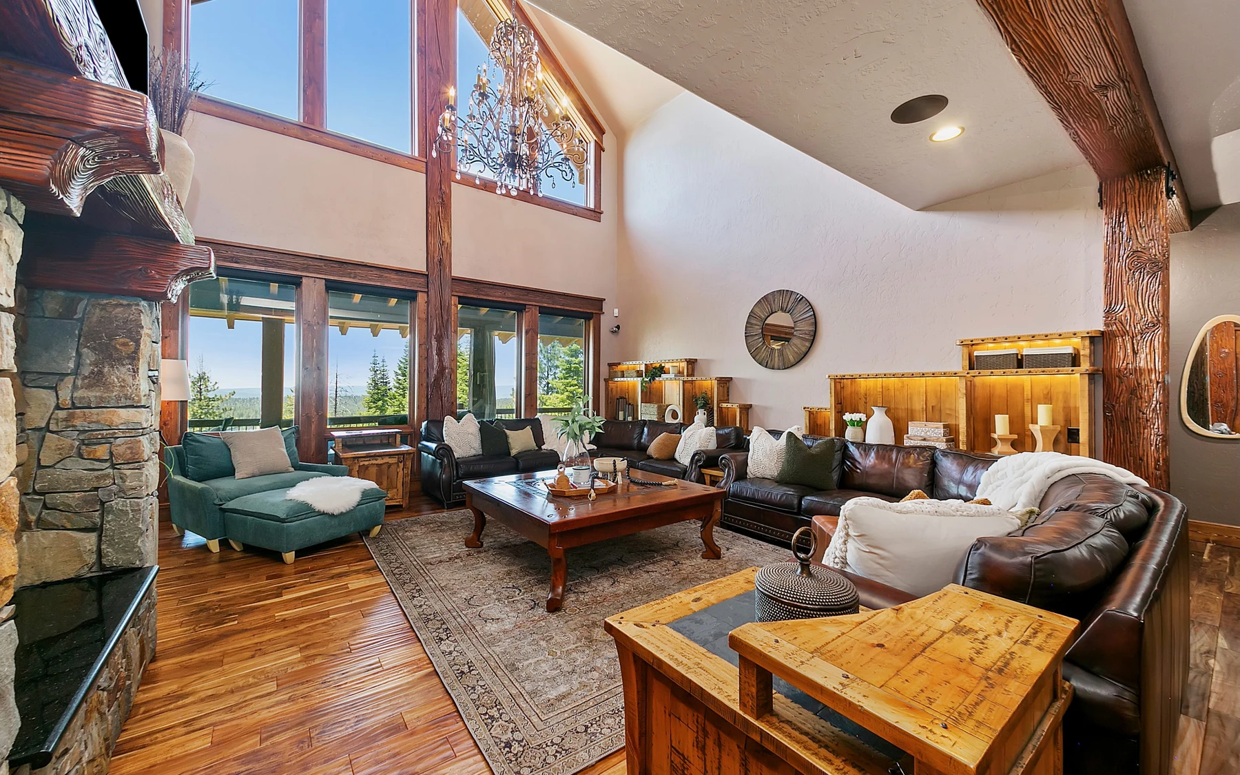 Living room in the Summit Sanctuary ridgeline home near McCall, with a relaxed seating area, large windows, and warm wood finishes.