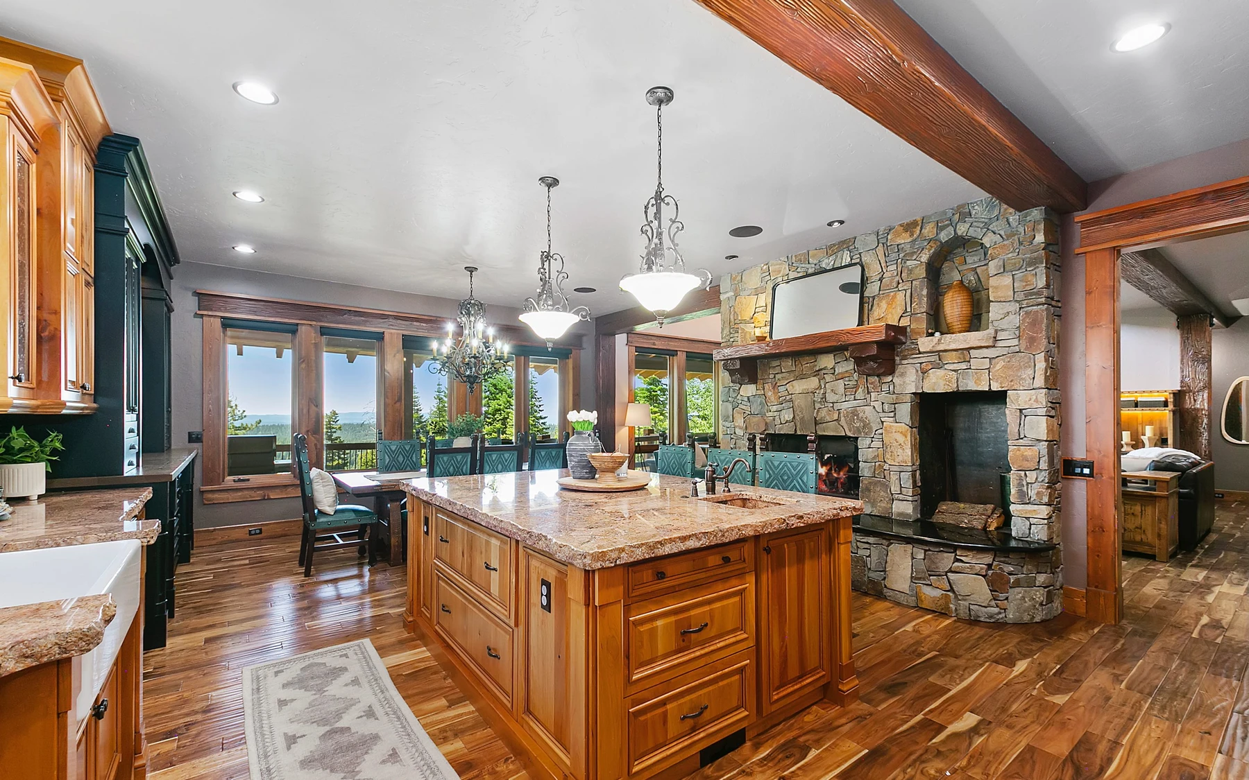 Kitchen in the Summit Sanctuary ridgeline home near McCall, with wood cabinetry, stone surfaces, and pendant lighting.