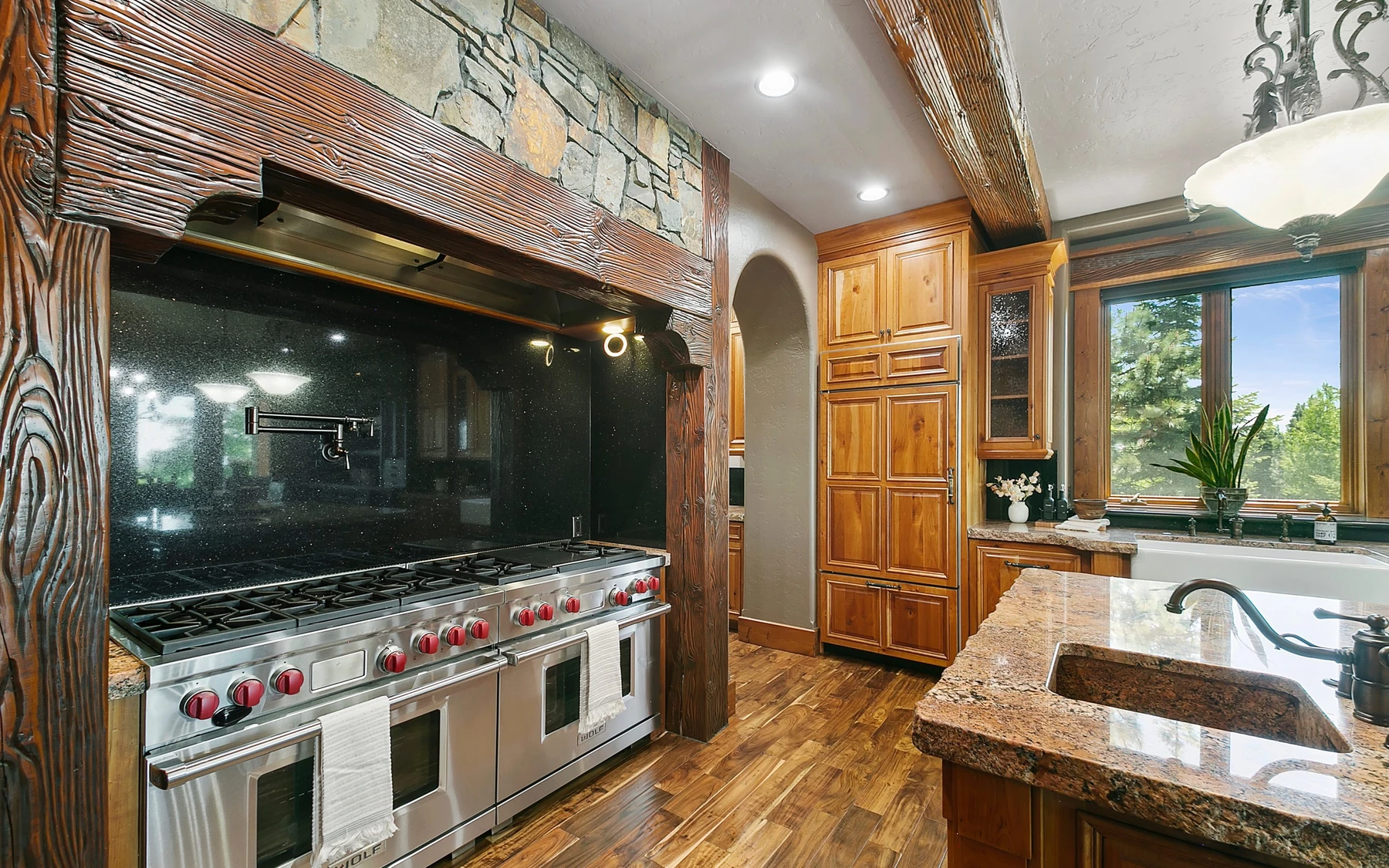 Kitchen in the Summit Sanctuary ridgeline home near McCall, with wood cabinetry, a broad countertop, and integrated appliances.