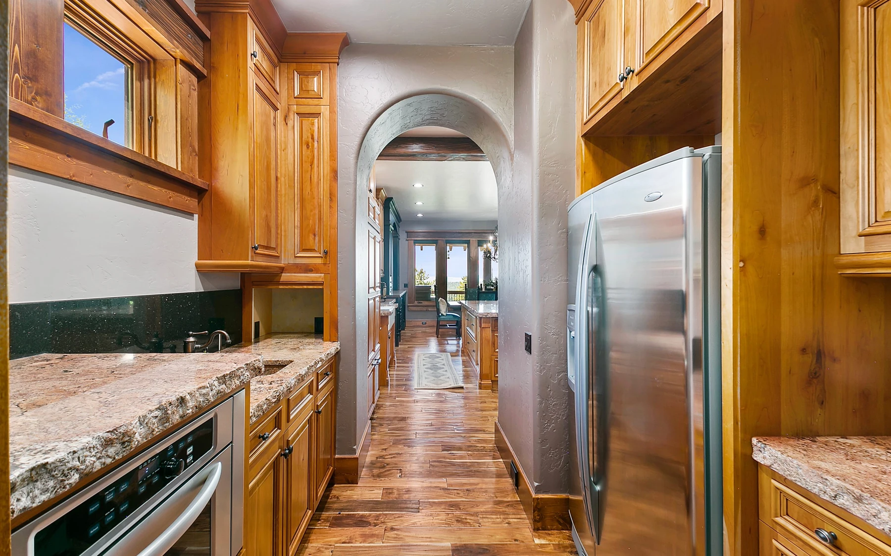 Kitchen in the Summit Sanctuary ridgeline home near McCall, with wood cabinetry, a broad countertop, and integrated appliances.