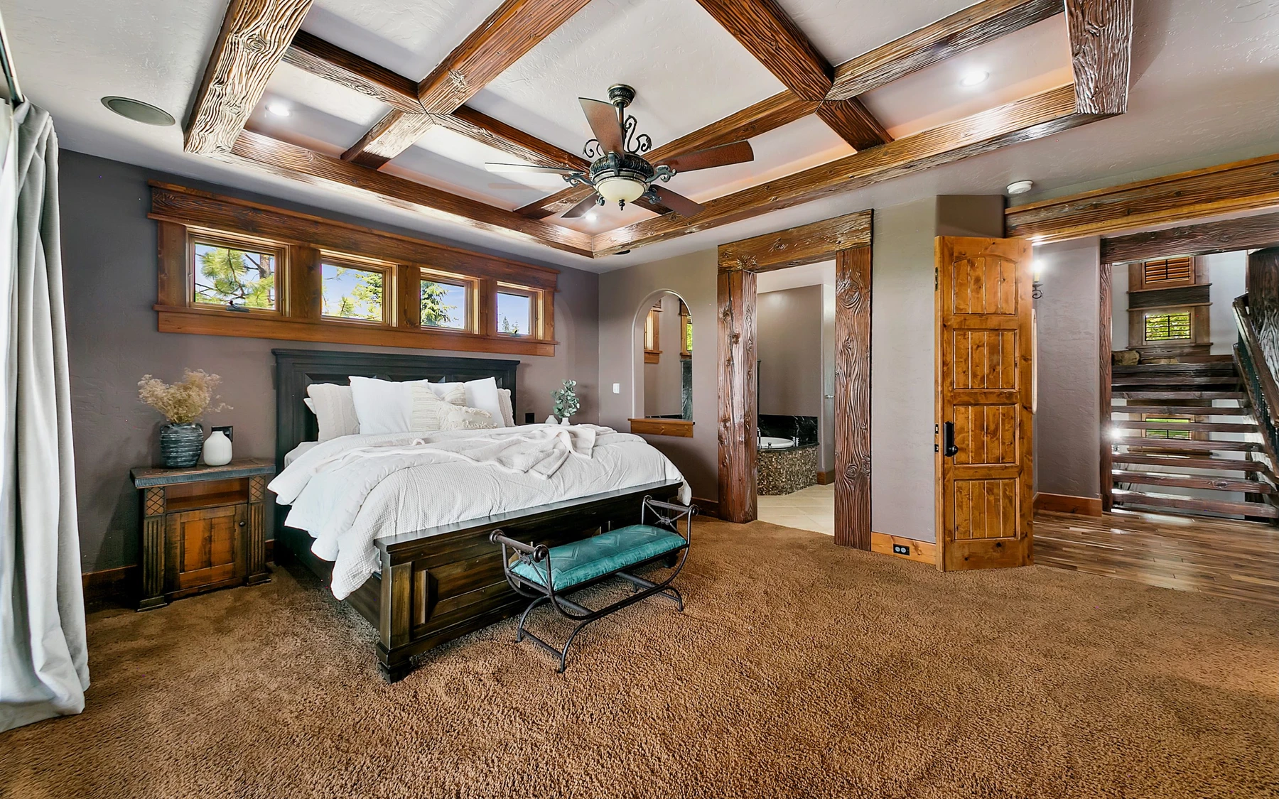 Bedroom in the Summit Sanctuary ridgeline home near McCall, with a layered bed and wood details.
